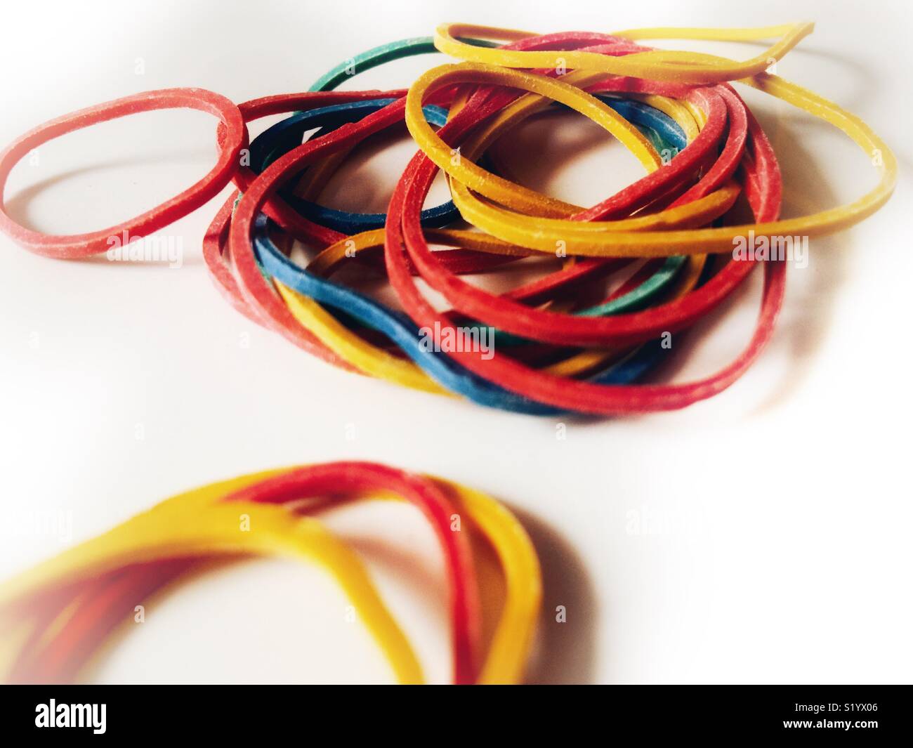 Pile of coloured rubber bands on white background Stock Photo