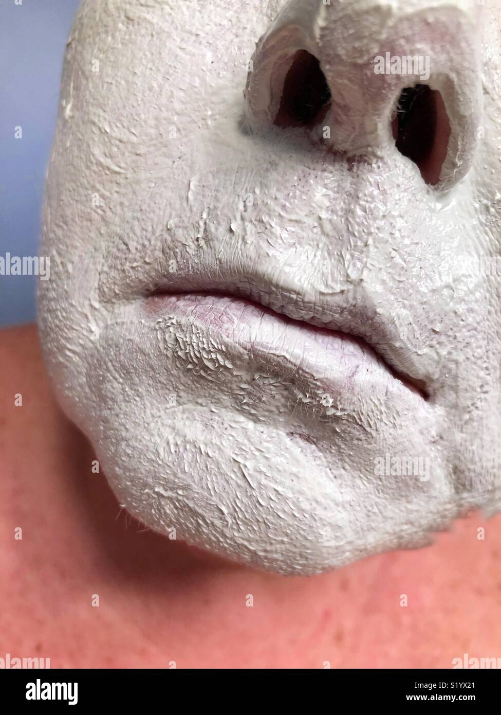 A closeup of the nose and mouth of a Caucasian woman wearing a white clay mud mask Stock Photo