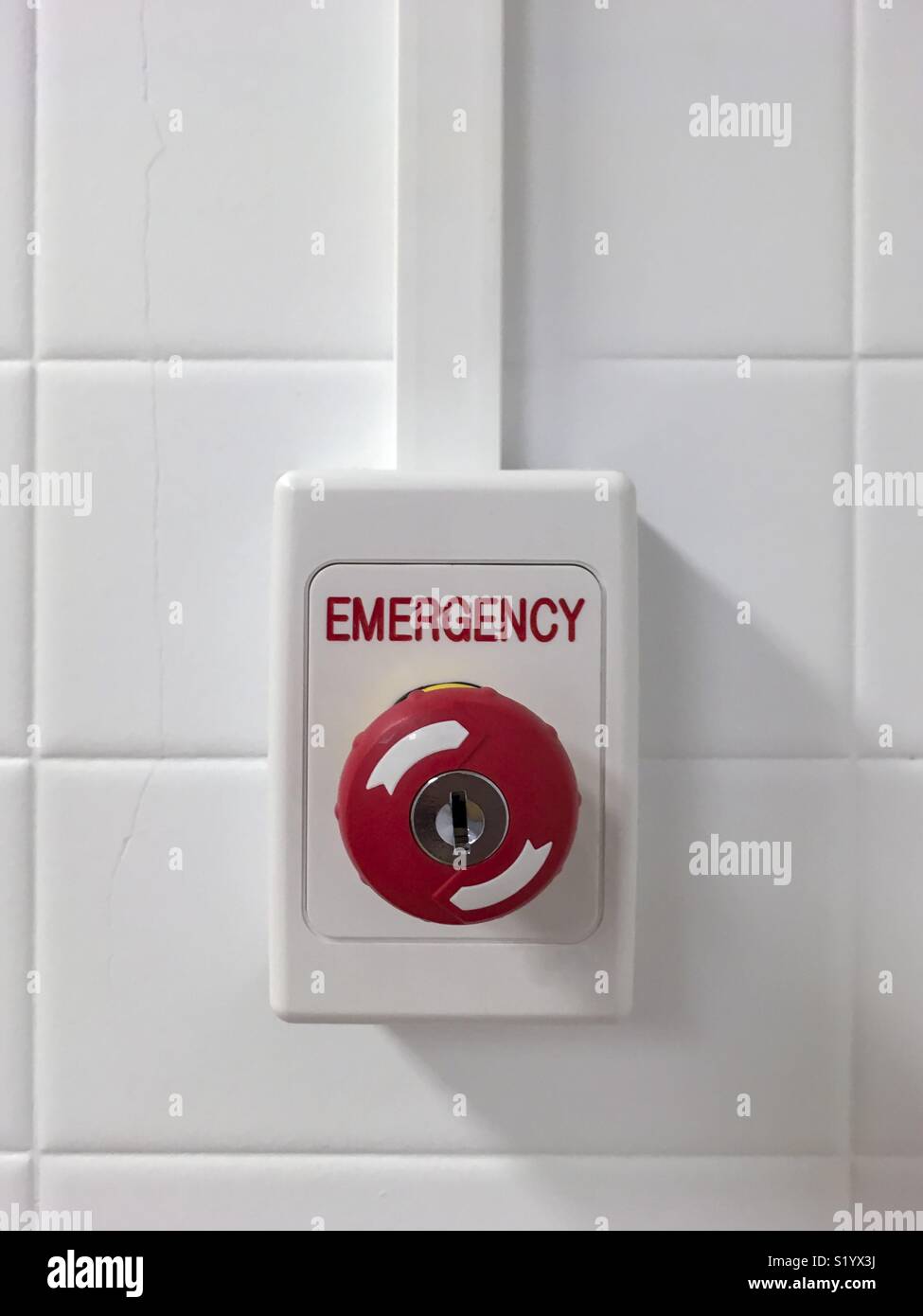 Emergency push button against a white wall. - Smartphone Captured Stock Image
