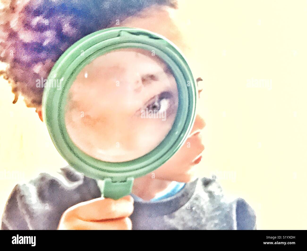 Boy looking through a magnifying glass. Stock Photo