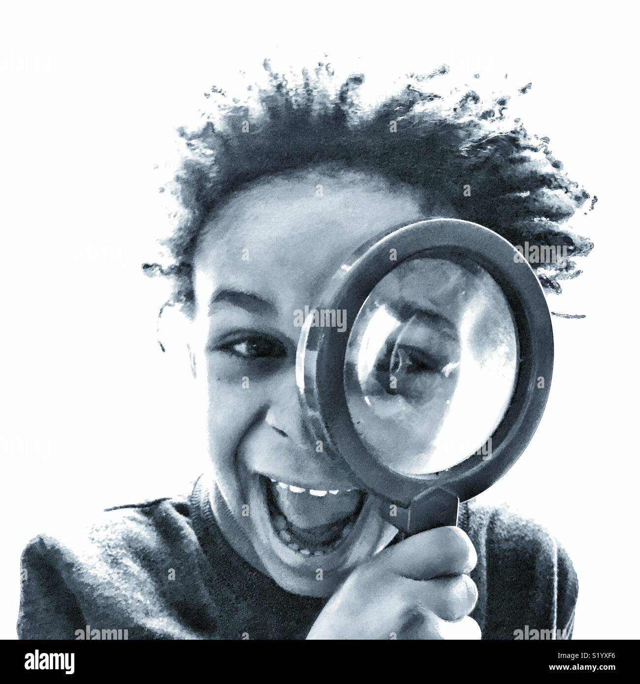 A laughing boy looks through a magnifying glass Stock Photo Alamy