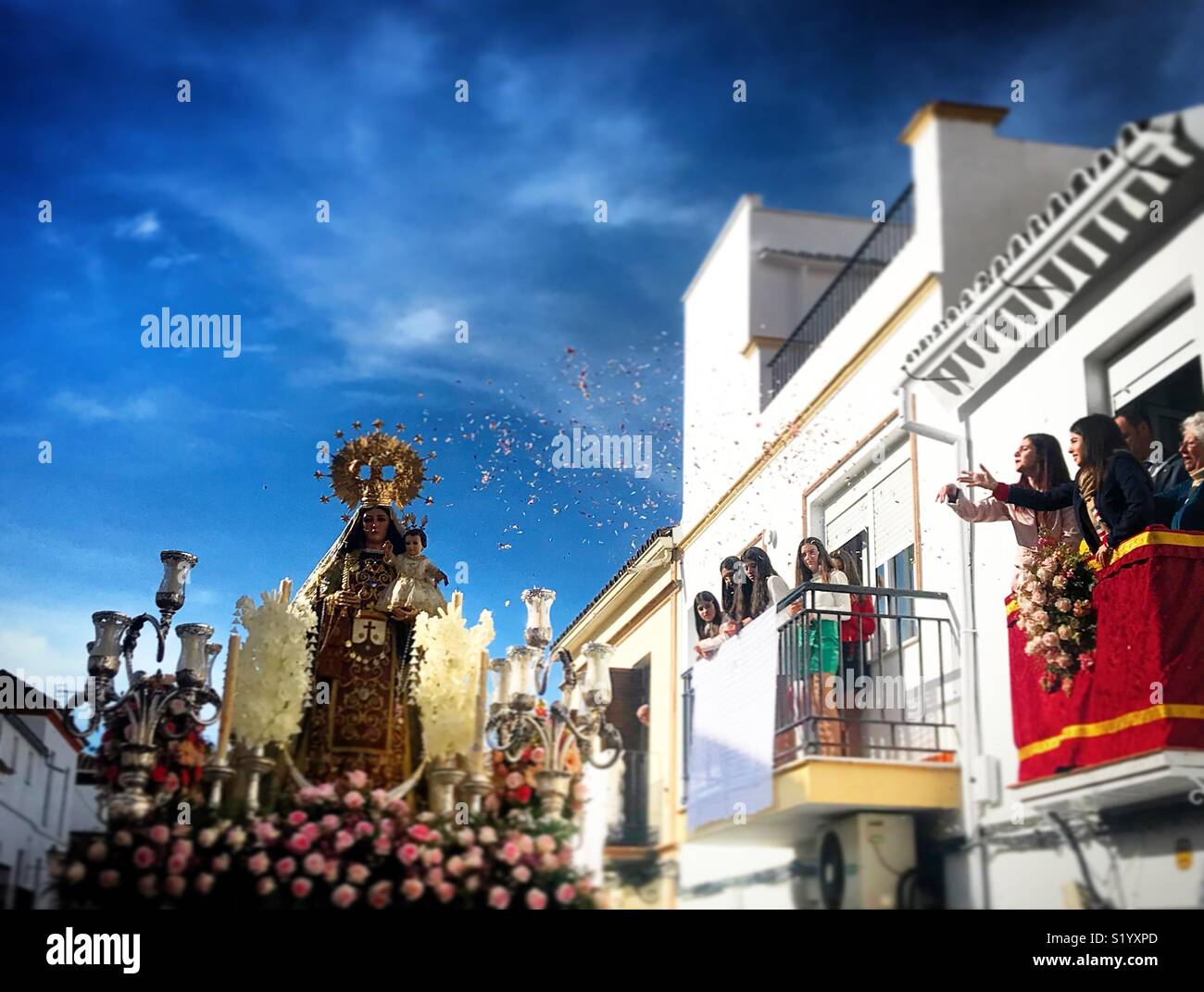 A woman trows rose petals to an image of Our Lady of Carmel during easter holy week in Prado del Rey, Sierra de Cadiz, Andalusia, Spain - Smartphone Captured Stock Image