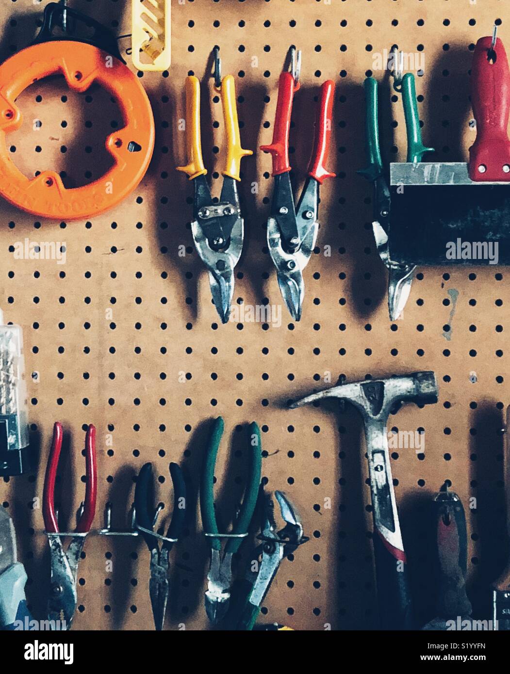 Pegboard full of random tools in a garage Stock Photo