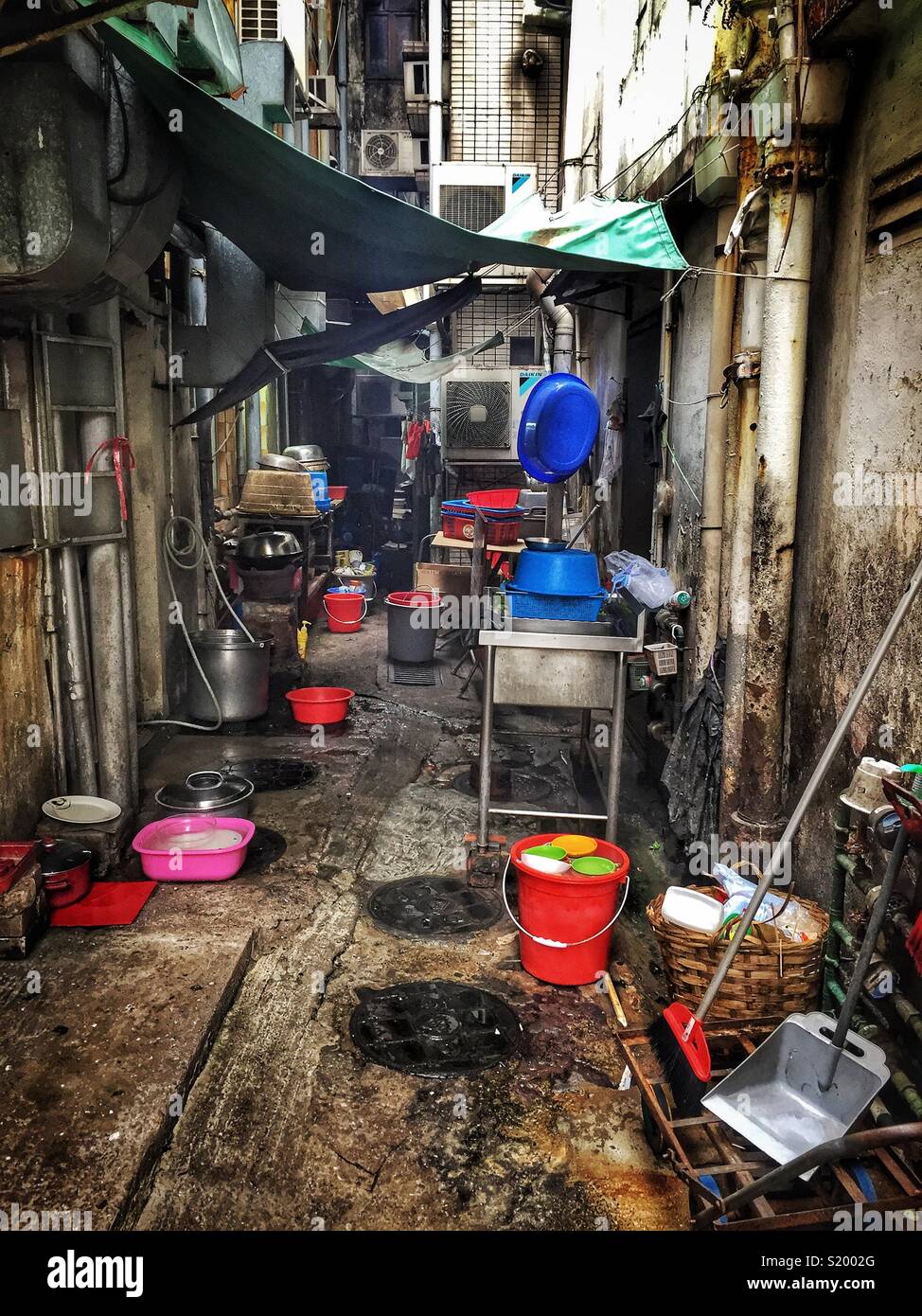 Restaurant dishes are washed in bowls and buckets in a back alley on Peng Chau, an Outlying