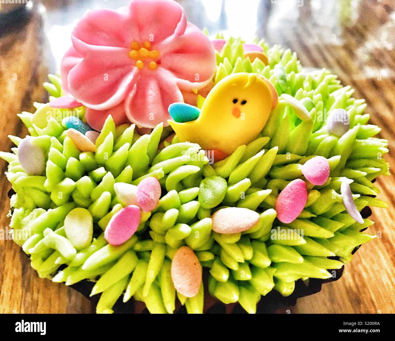 Easter cupcake with cute sugar chick, eggs flower and frosting grass - Smartphone Captured Stock Image