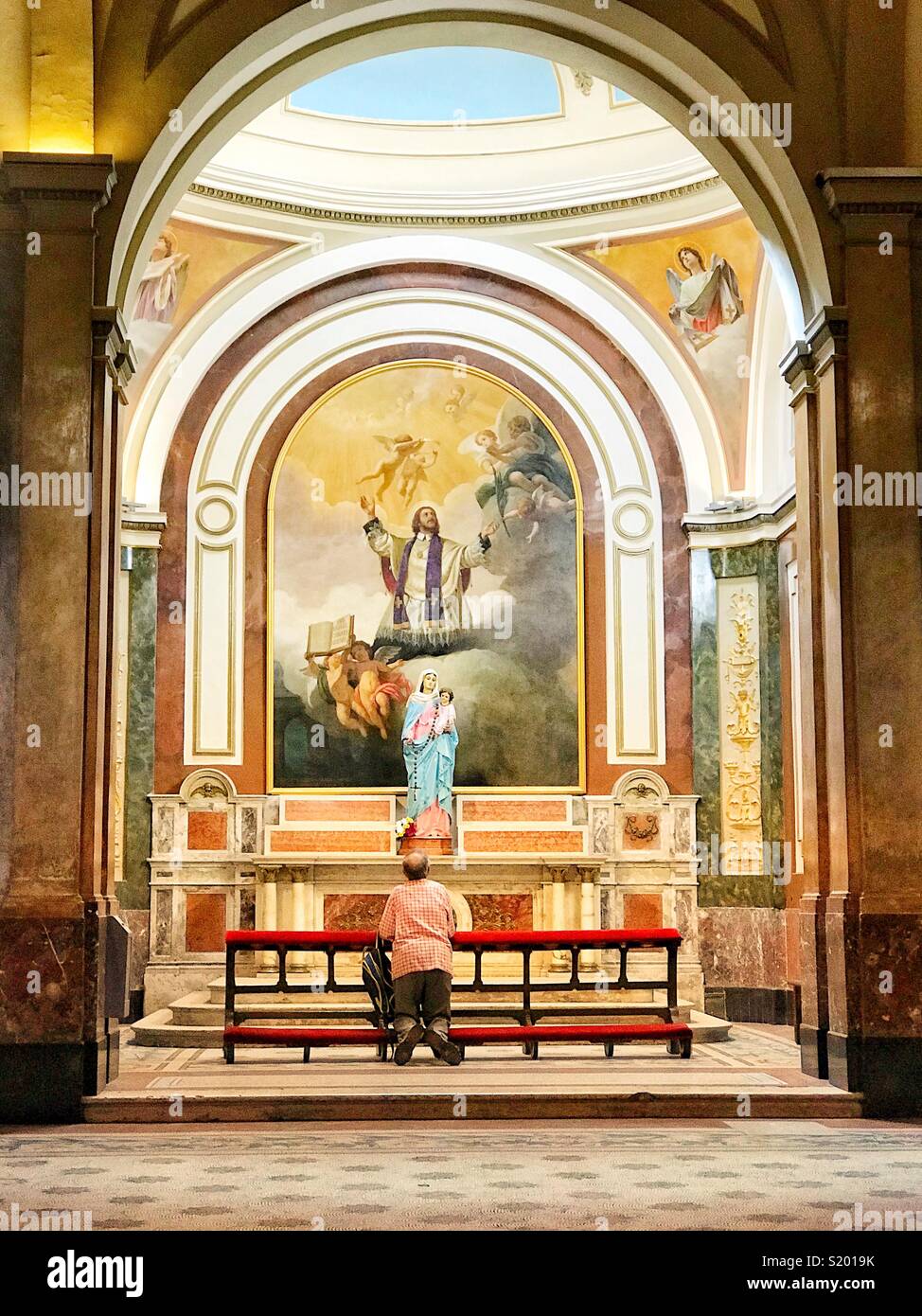 Man praying in Catedral Metrpolitana, Buenos Aires, Argentina - Smartphone Captured Stock Image