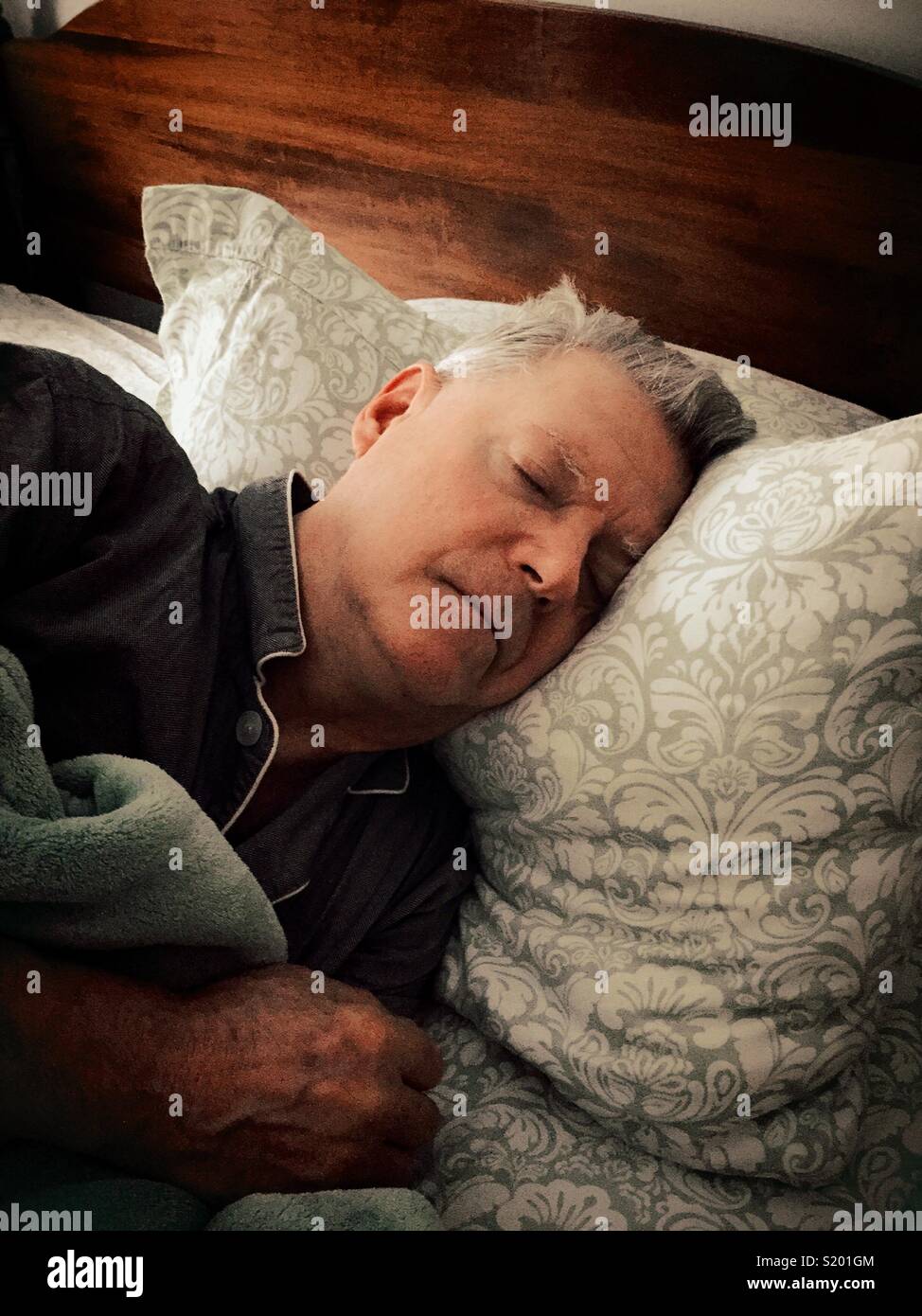 Senior man sleeping soundly in his bed, United States - Smartphone Captured Stock Image