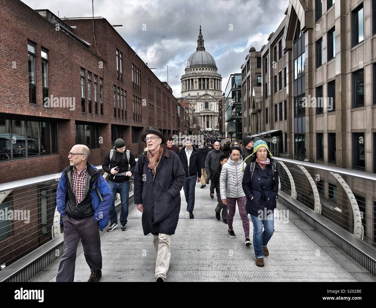 Pedestrians cross the Millennium Footbridge in London, England - Smartphone Captured Stock Image