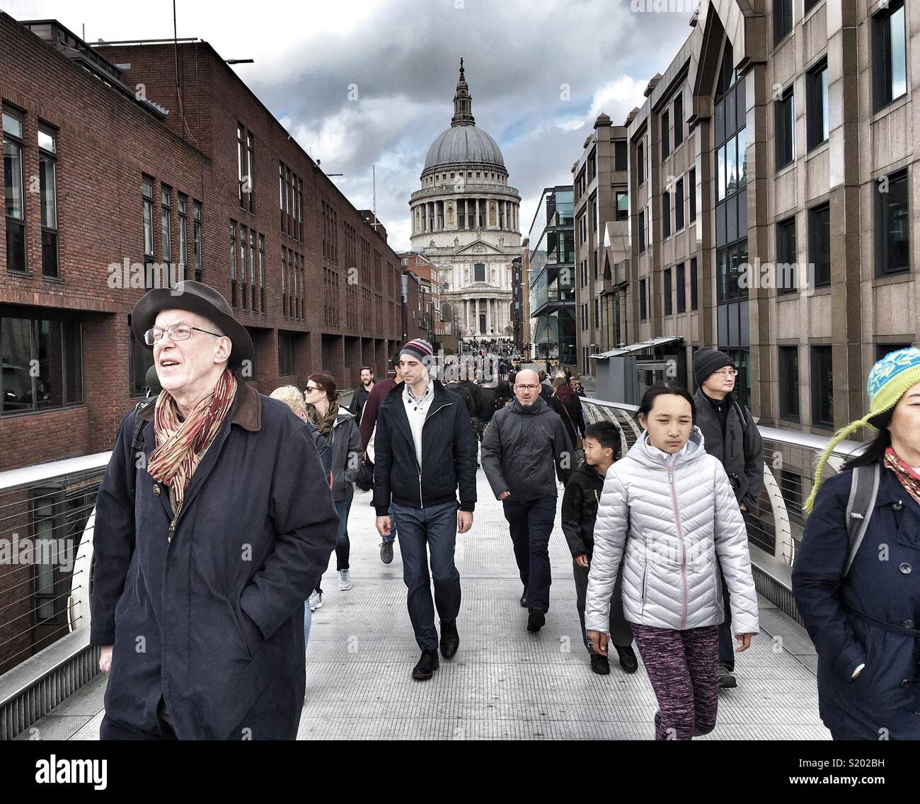 Pedestrians cross the Millennium Footbridge in London, England - Smartphone Captured Stock Image
