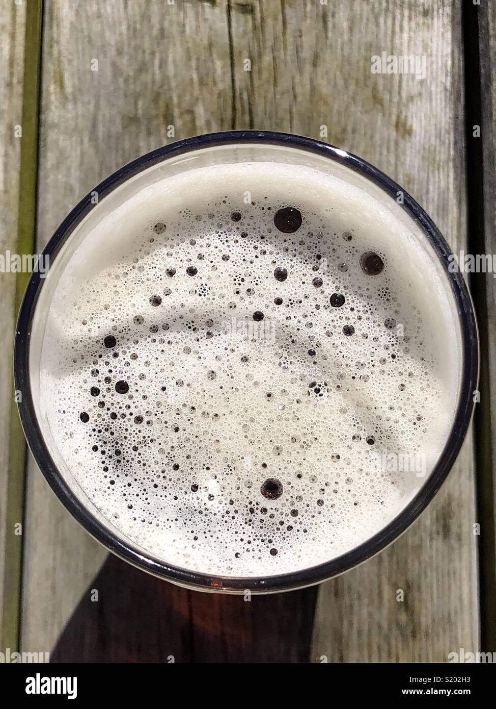 Overhead capture of a pint of ale beer on a wooden bench Stock Photo