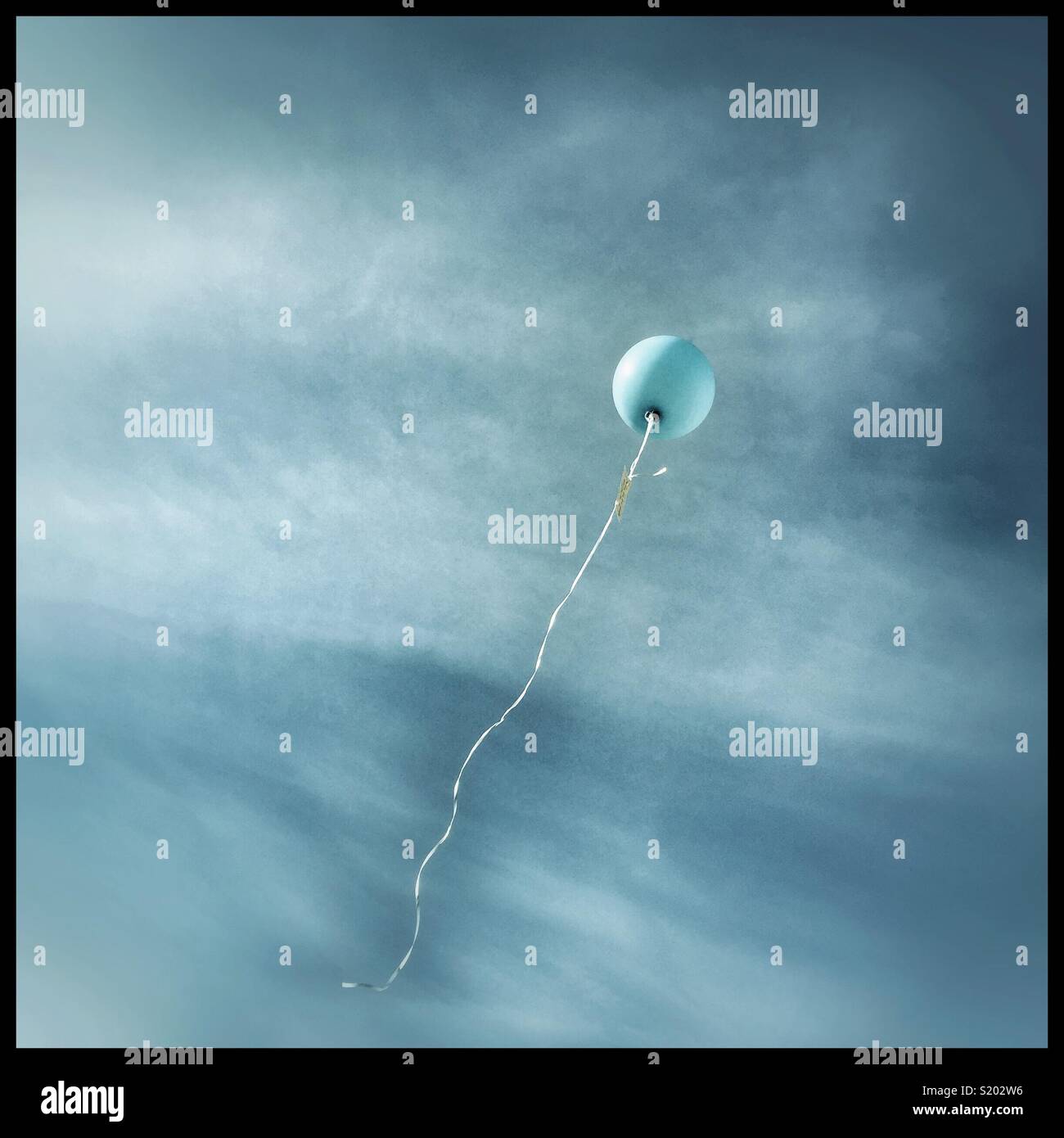 Lone blue balloon rising skyward - Smartphone Captured Stock Image
