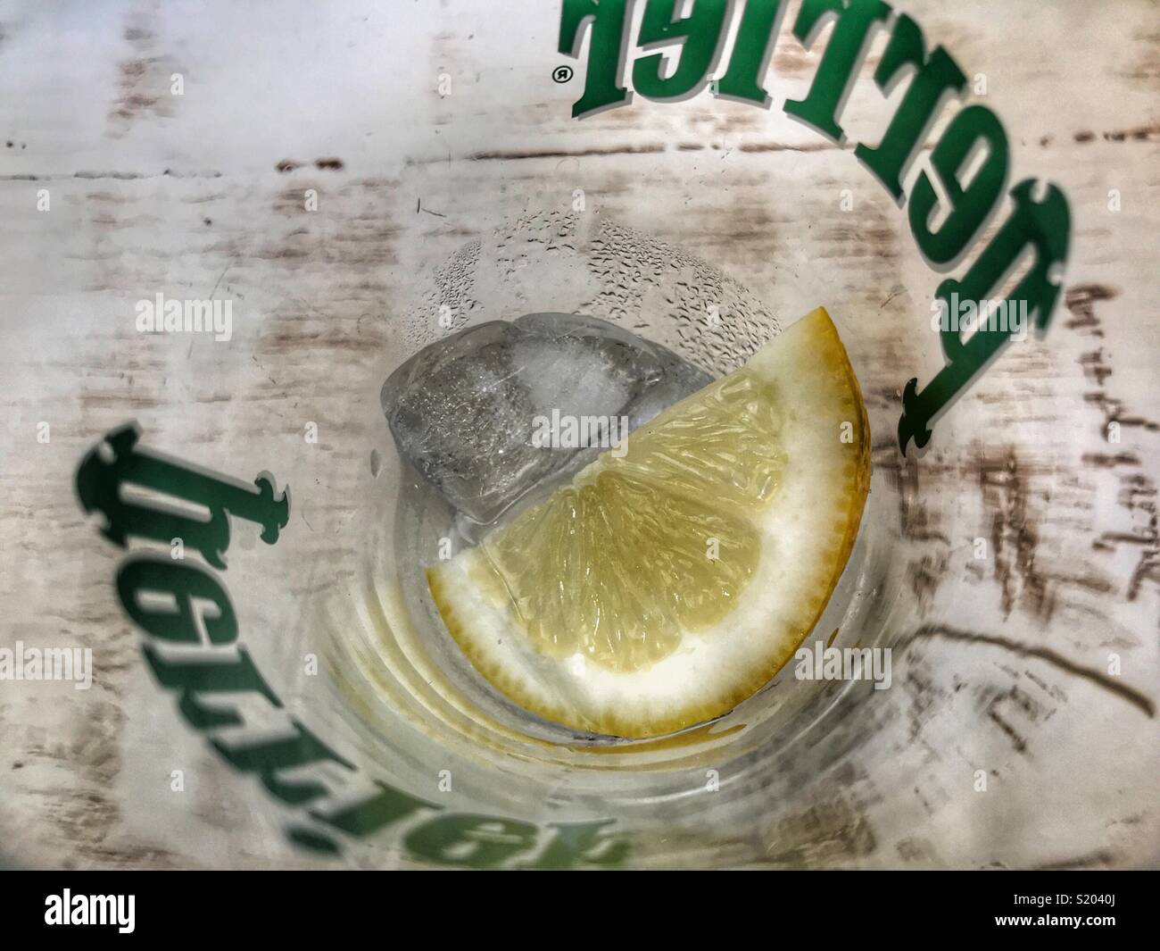 Glass of Perrier water with ice and a slice in a branded glass, high angle view Stock Photo