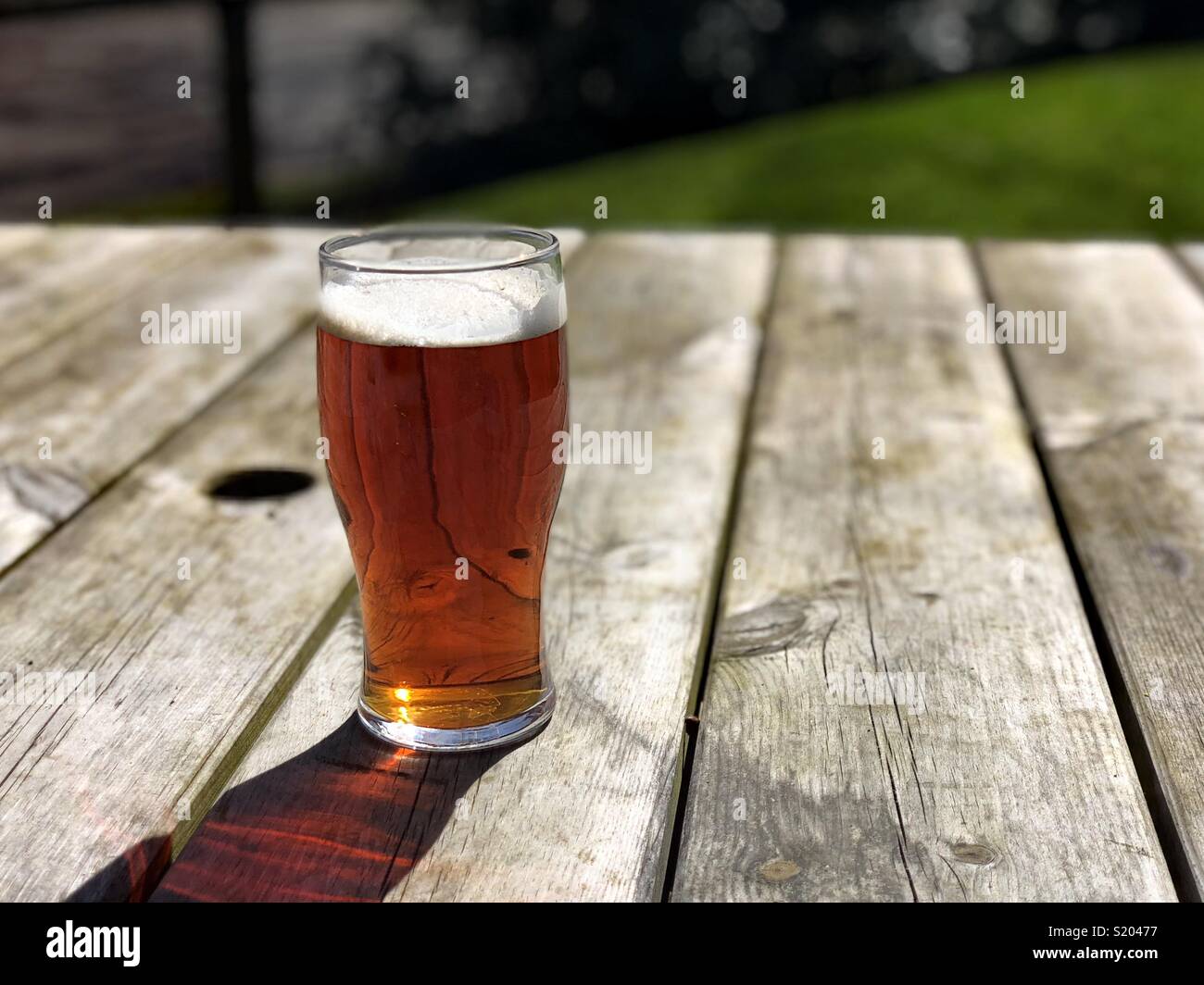 Pint of ale beer on beer garden table - Smartphone Captured Stock Image