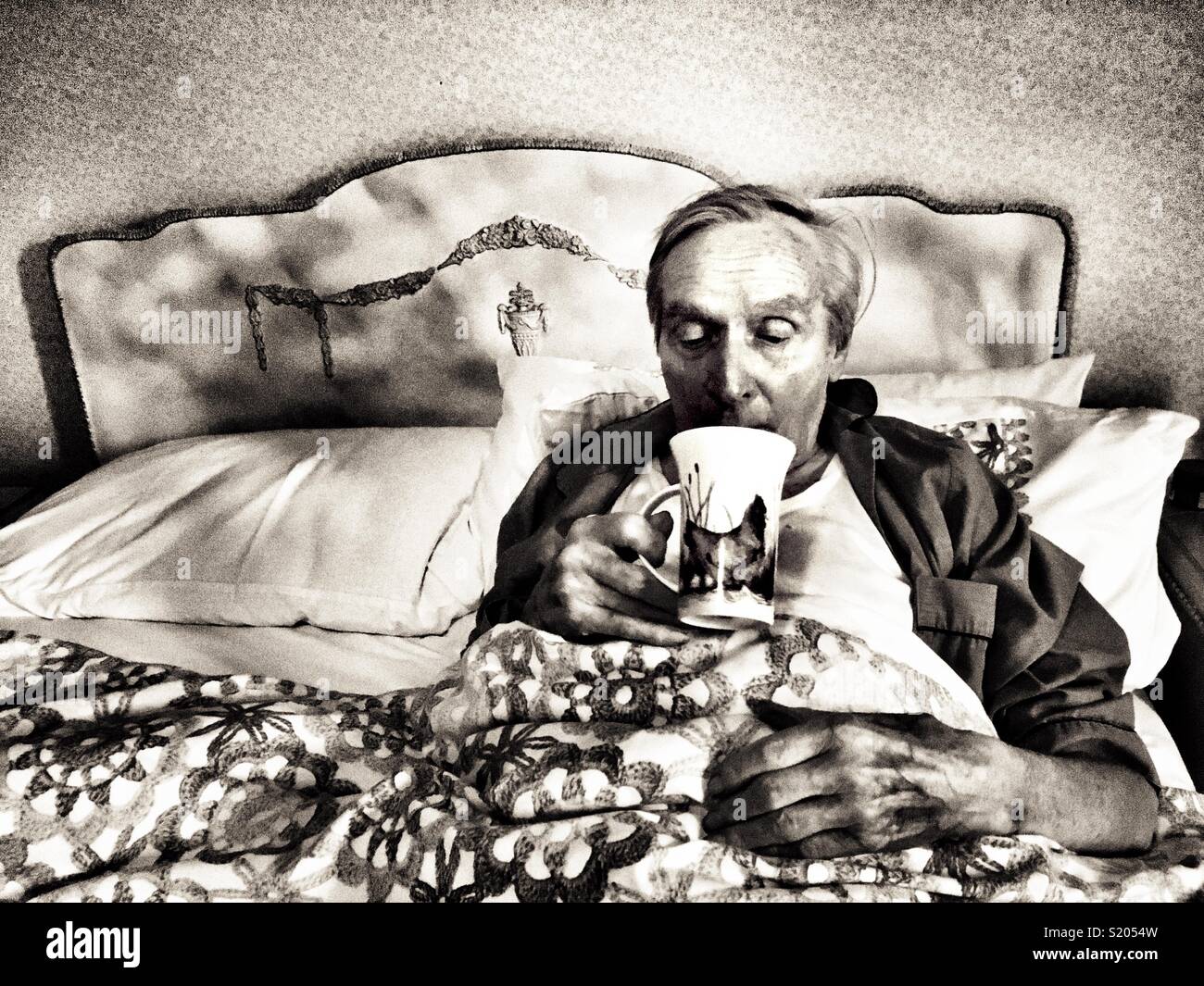 Elderly man drinking a cup of tea in bed UK - Smartphone Captured Stock Image