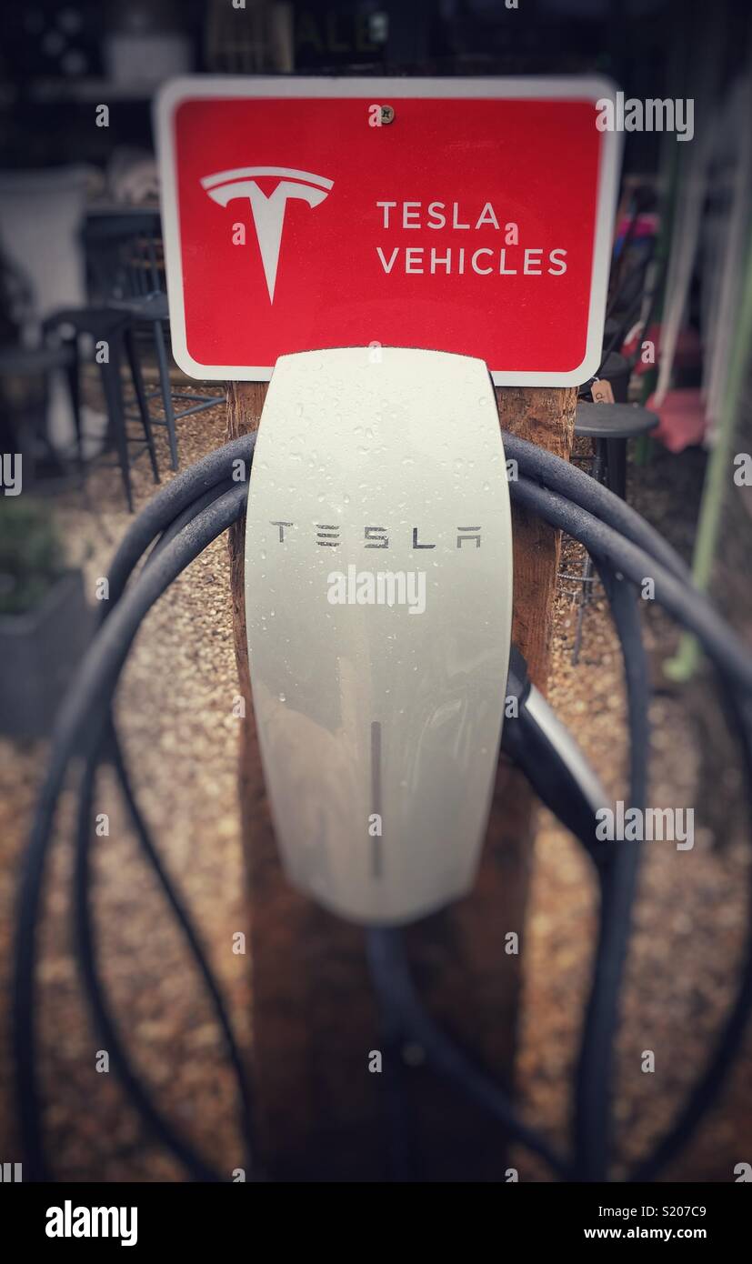 A Tesla electric car charging point with sign - Smartphone Captured Stock Image
