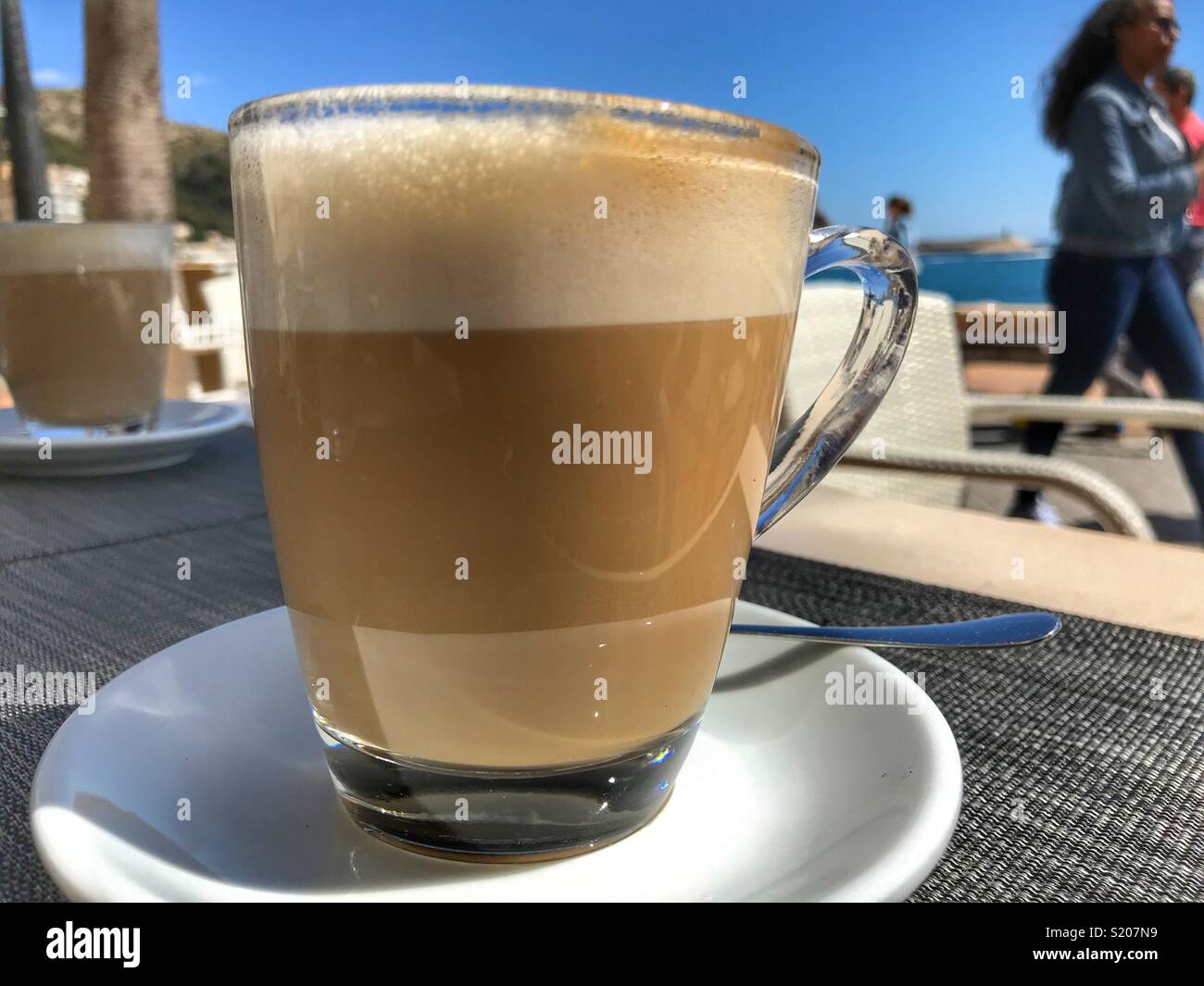 https://c8.alamy.com/comp/S207N9/cafe-con-leche-milky-white-coffee-on-a-table-in-a-cafe-on-the-waterfront-promenade-in-the-port-area-of-javea-xabia-on-the-costa-blanca-alicante-province-comunidad-valenciana-spain-S207N9.jpg