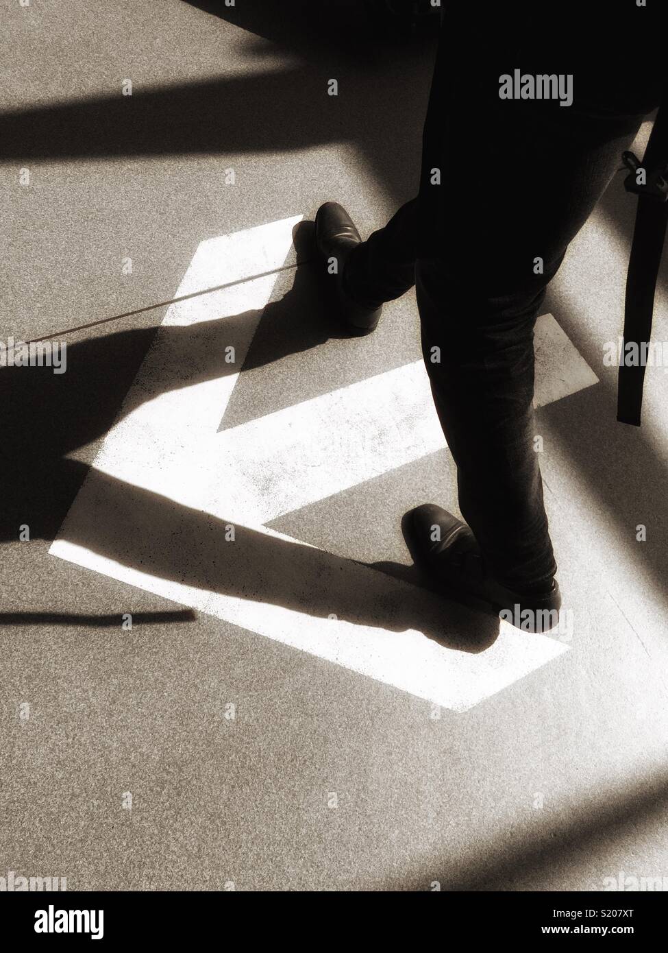 Walking against a direction arrow - Smartphone Captured Stock Image