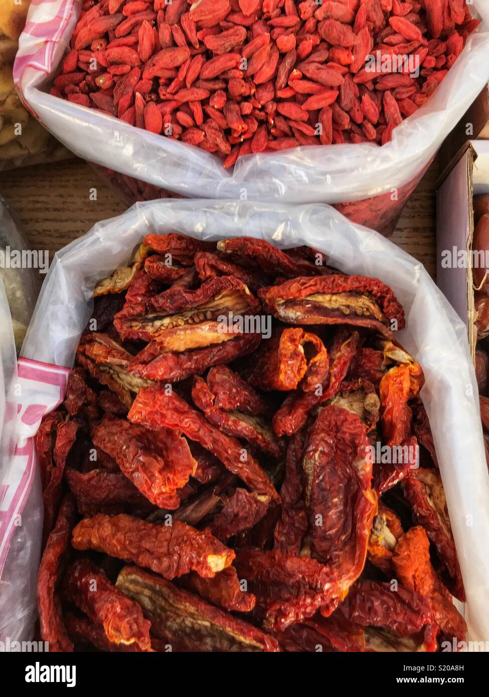 Dried fruits stall, including goji berries and sun dried tomatoes, at an outdoor market in Javea, Spain. Stock Photo