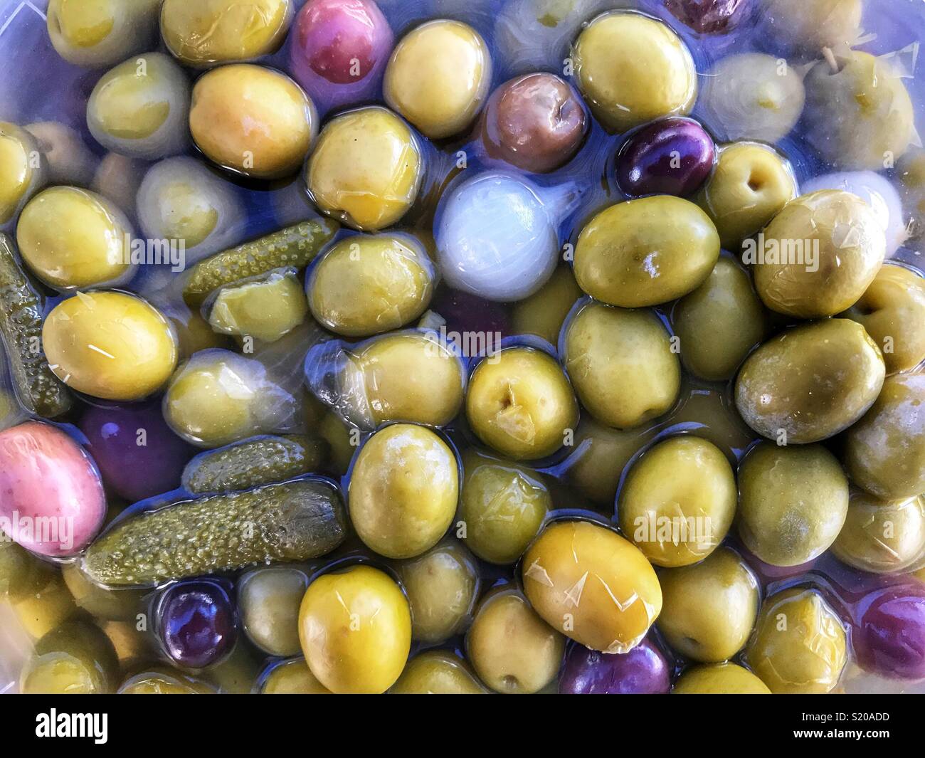 Mixed green olives, black olives, gherkins, pickled onions, at the Thursday Market in Javea, Spain - Smartphone Captured Stock Image