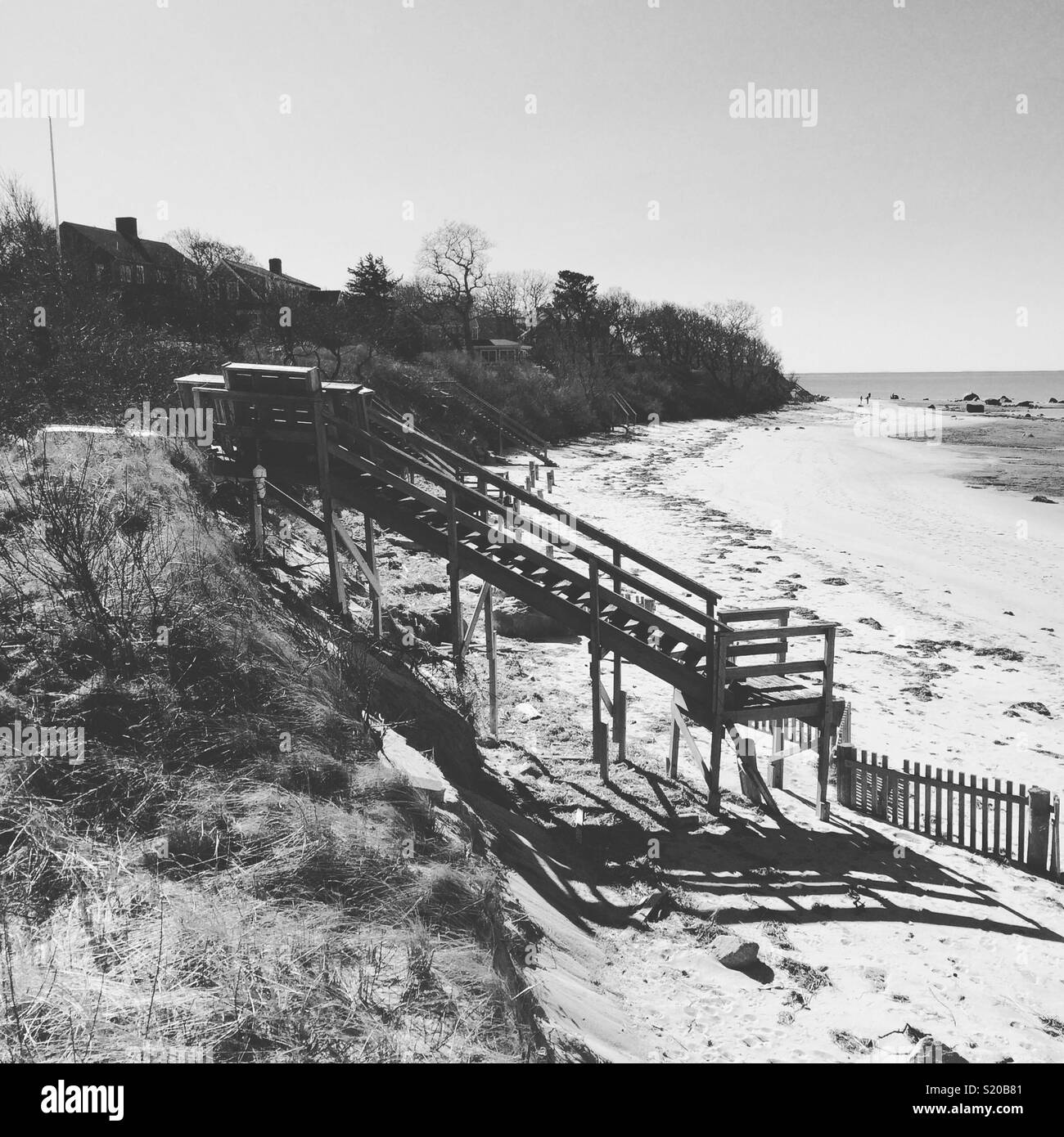 A black and white winter view of steps to a beach, Cape Cod, Massachusetts, United States - Smartphone Captured Stock Image