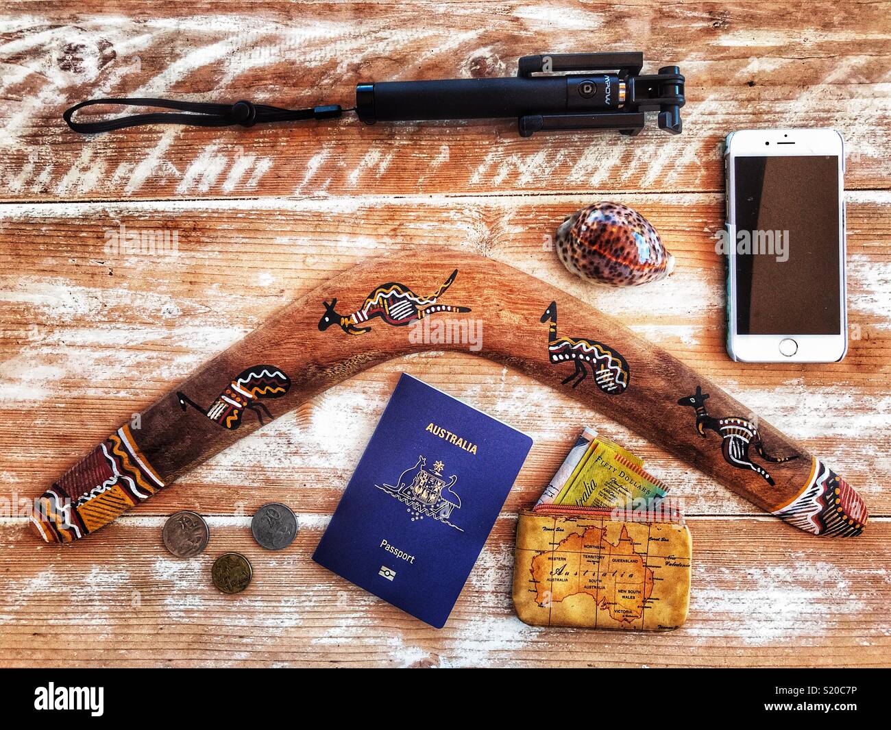 Flatlay photography, Australia holiday travel theme, boomerang, Australian passport, purse, AUD $, money, mobile phone, selfie stick, cowrie shell - Smartphone Captured Stock Image