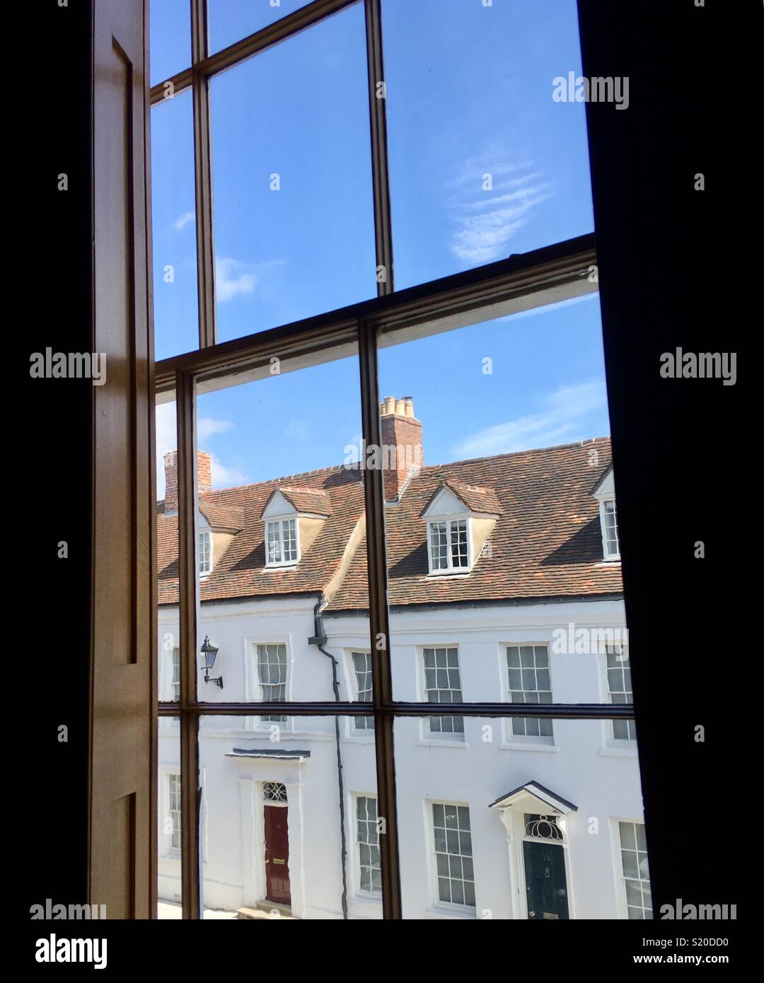 Georgian houses under a blue sky seen through a sash window Stock Photo