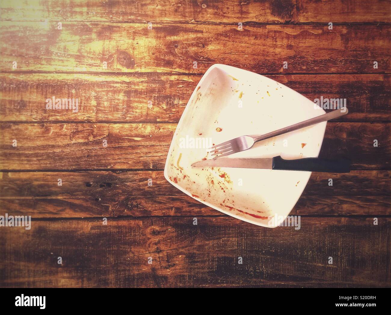 Dirty plate with fork and knife after having eaten the dish, food concept with copy space. - Smartphone Captured Stock Image