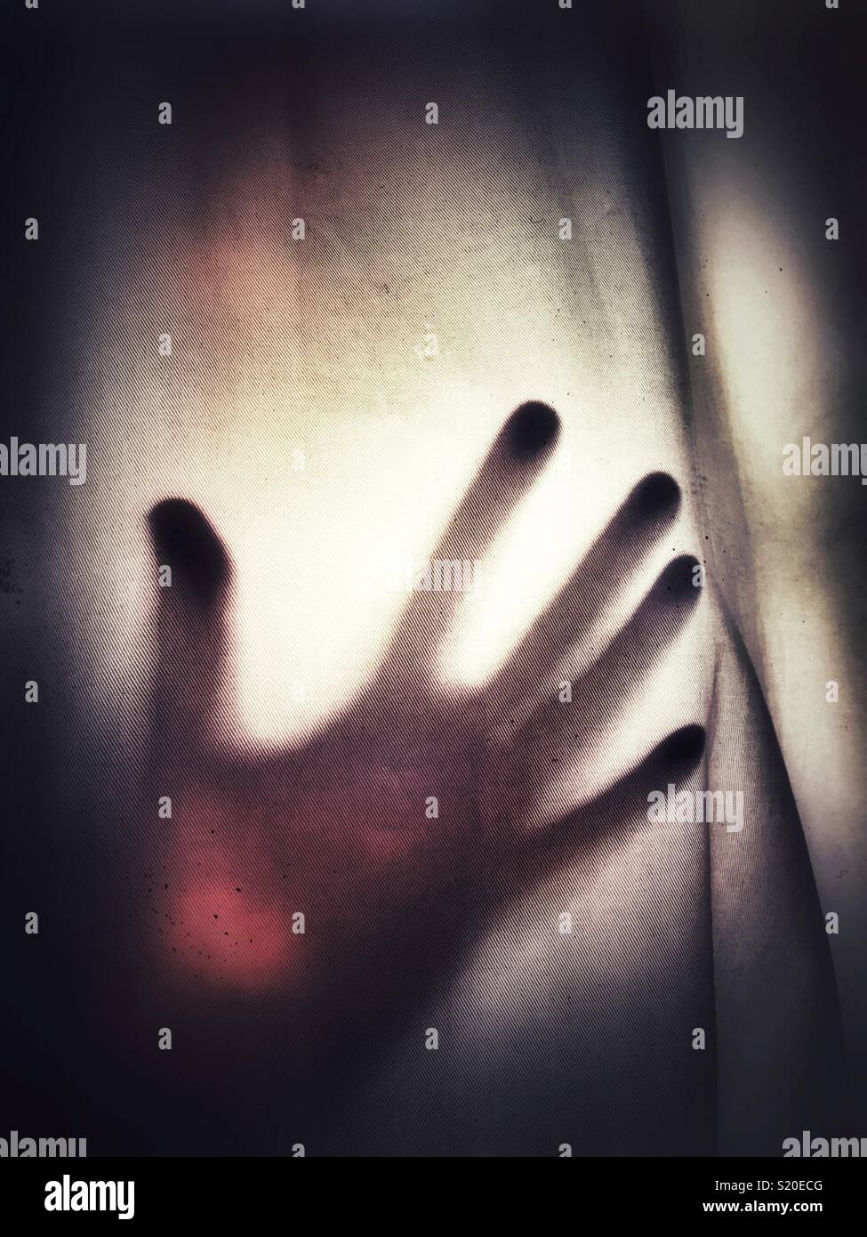 A silhouette of an outstretched hand against a see through fabric - Smartphone Captured Stock Image