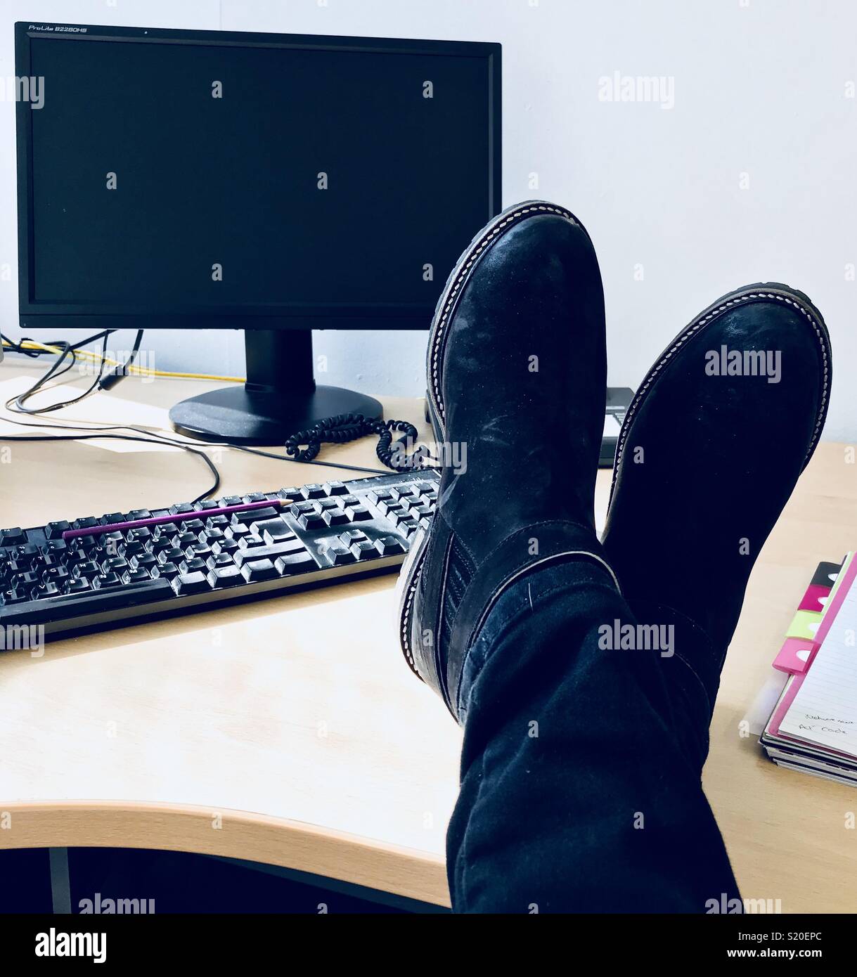 Office life, bored at work, feet on desk, taking a break Stock Photo