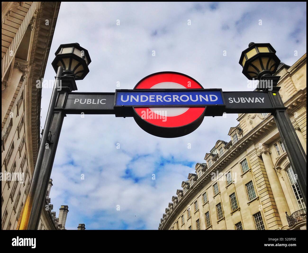 The iconic logo of London’s Underground Transport System. This sign indicates the entrance to Piccadilly Underground Tube/Train Station. Photo Credit - © COLIN HOSKINS. - Smartphone Captured Stock Image