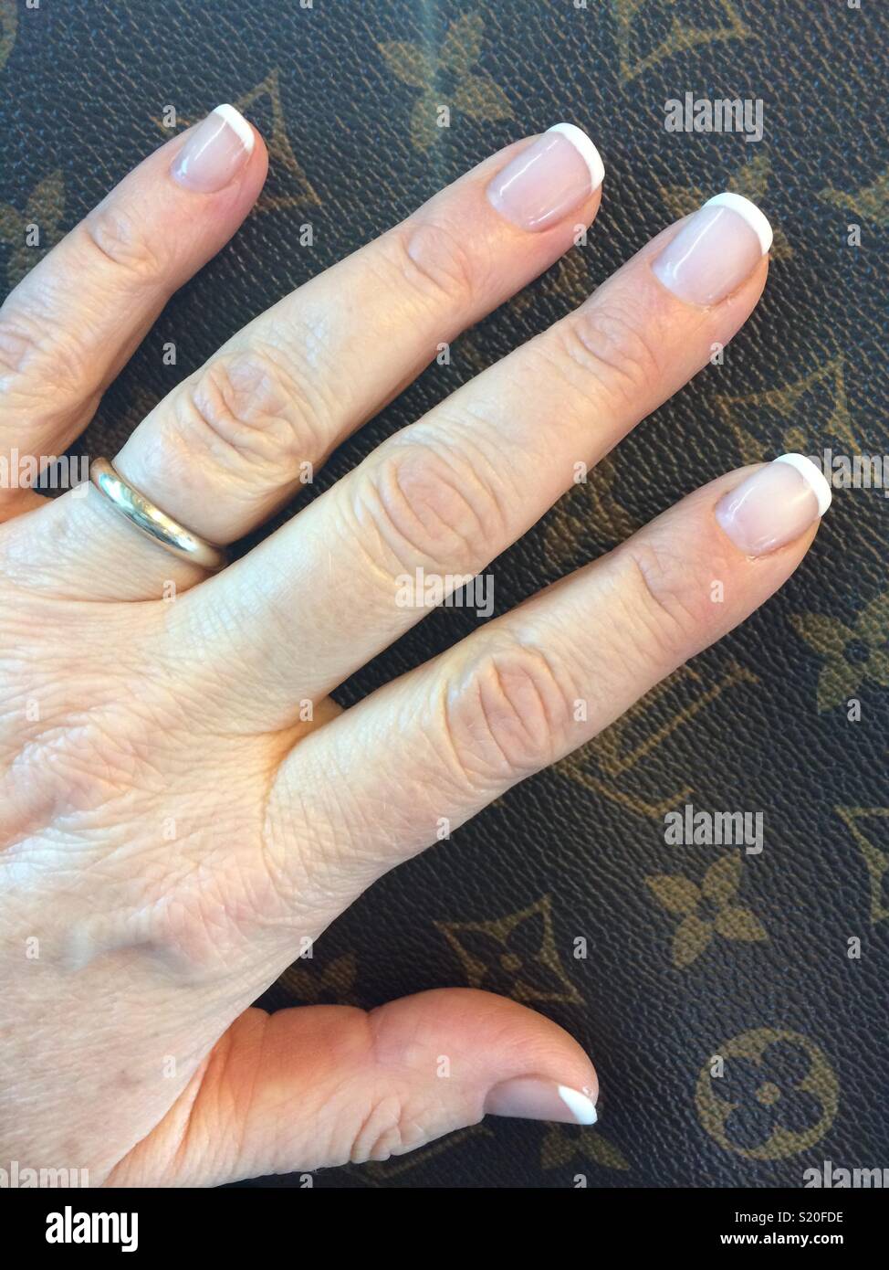 Left hand with french manicure. - Smartphone Captured Stock Image