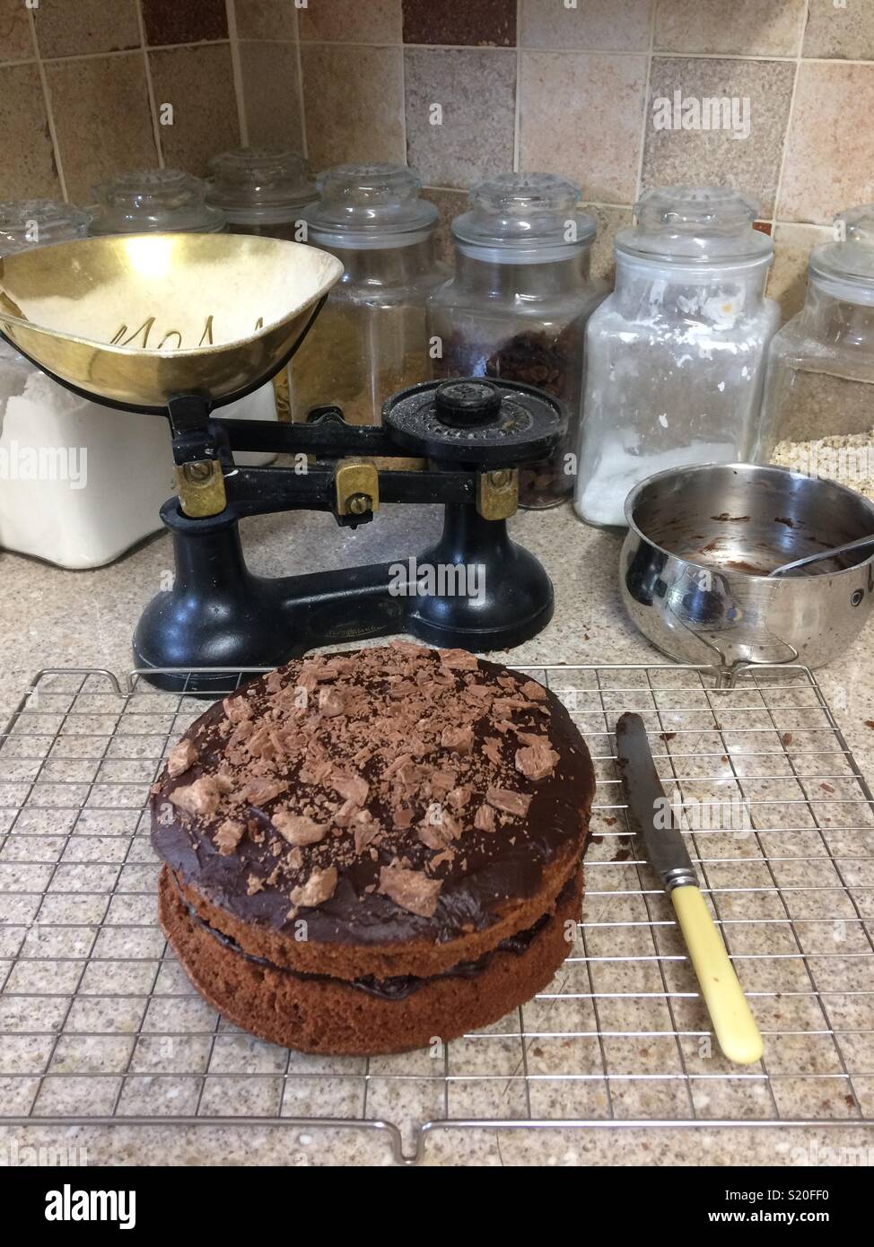 Freshly made chocolate cake on wire cooling rack in a country kitchen