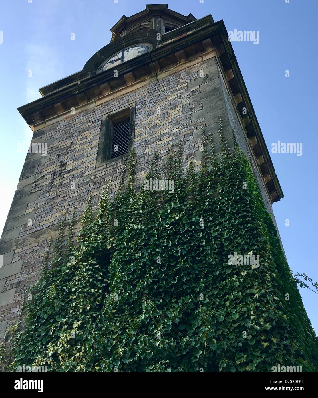 Stone clock tower and cupola, with ivy growing up it, at Drayton Manor Park, one time residence of Sir Robert Peel, Prime Minister to Queen Victoria, who visited in 1834. - Smartphone Captured Stock Image