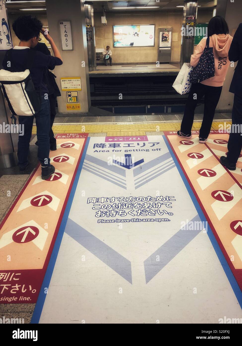 People waiting for a metro train in an orderly fashion. - Smartphone Captured Stock Image