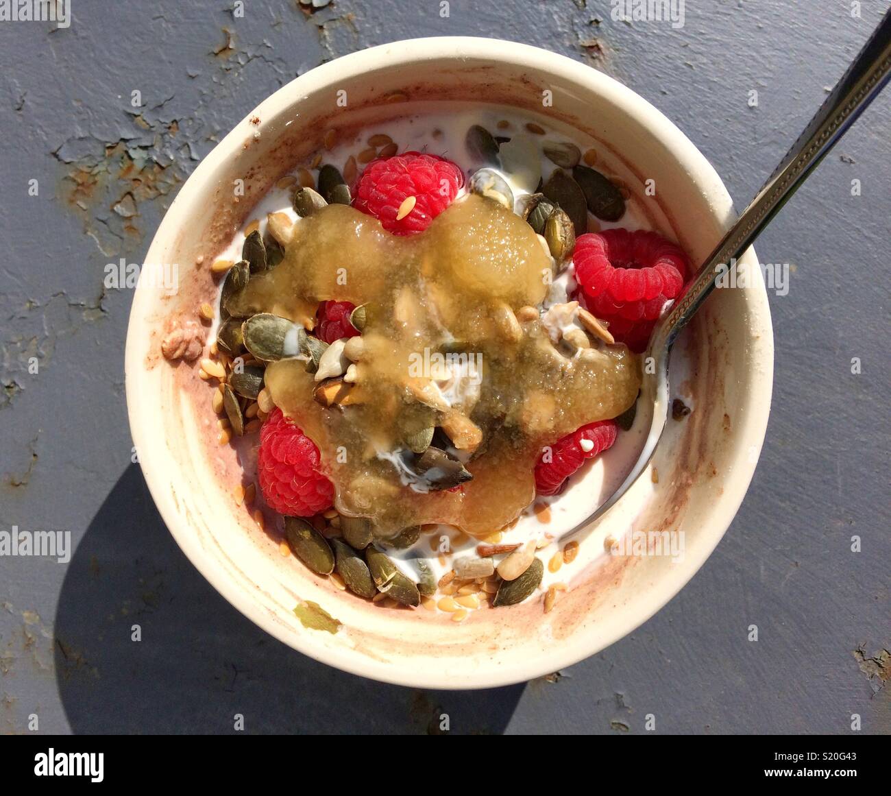 Bowl of chocolate porridge oats with yoghurt, raspberries, pumpkin seeds, cocoa, cream & honey - Smartphone Captured Stock Image