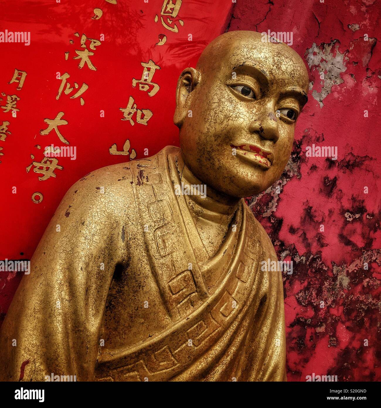 One of the Golden statues of Buddhist 'arhats' lining the path leading to the Ten Thousand Buddhas Monastery in Sha Tin, New Territories, Hong Kong - Smartphone Captured Stock Image