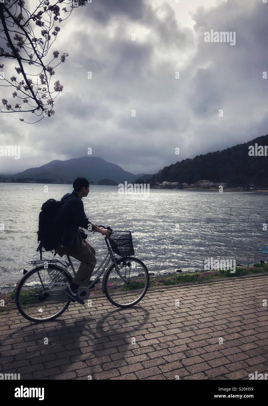 A young man cycles around Lake Kawaguchi in Japan. - Smartphone Captured Stock Image