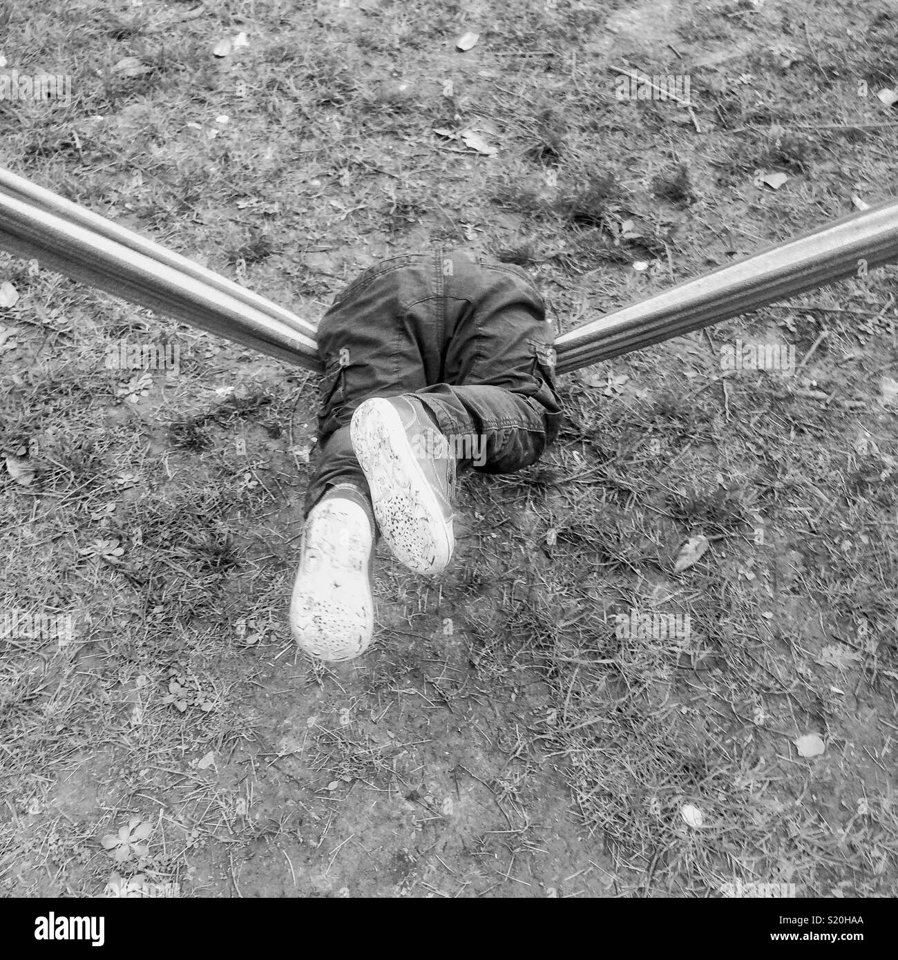 Eighteen month old baby boy playing on a garden hammock, Hampshire, England, United Kingdom. - Smartphone Captured Stock Image