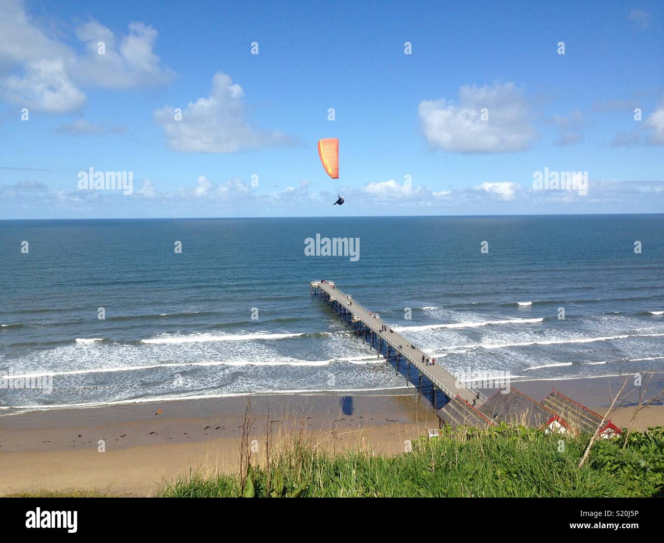 Freedom: paraglider over the coast Stock Photo