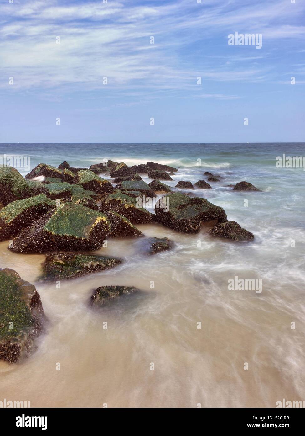 Moss-covered rocks at a beach down the Jersey Shore Stock Photo
