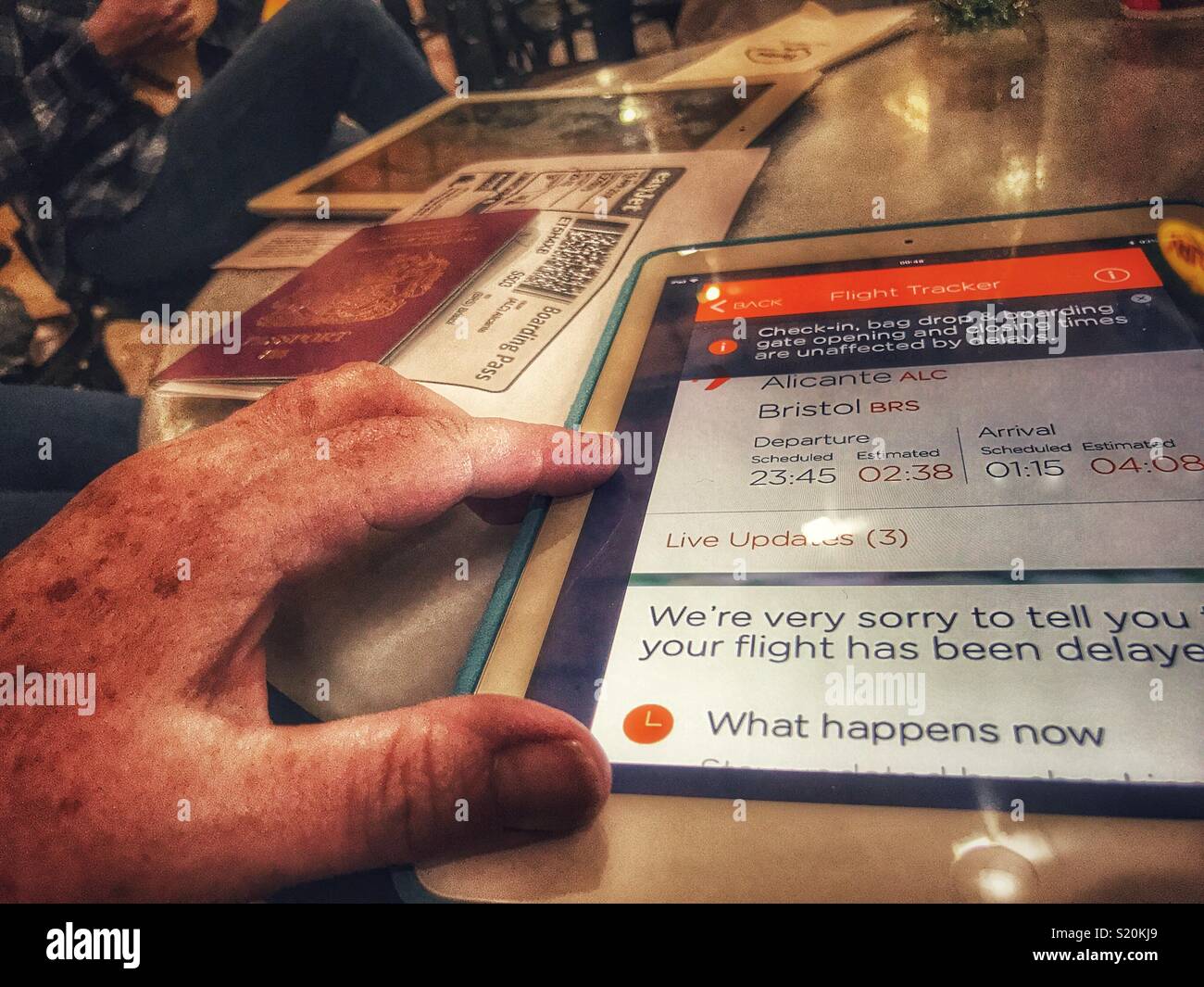 POV hand on an iPad with the EasyJet app open, showing flight delay information, El Altet Airport, Alicante, Spain - Smartphone Captured Stock Image