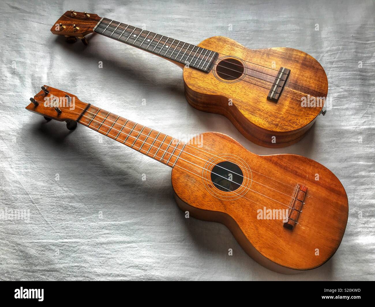 Two soprano ukuleles, both made of koa wood. An antique Aloha ukulele in  foreground, and a contemporary DJ Morgan ukulele behind Stock Photo - Alamy