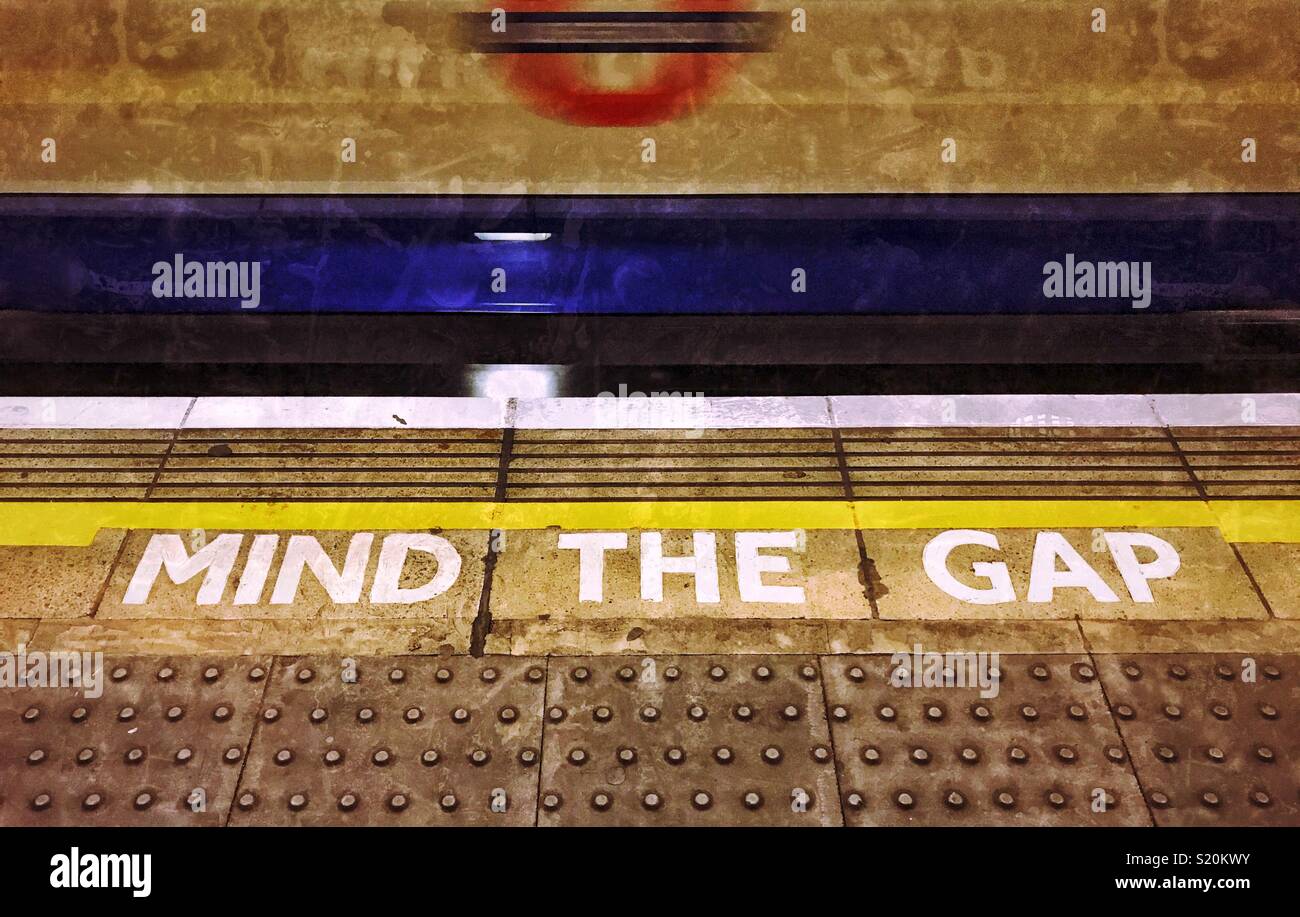A warning sign on The London Underground - MIND THE GAP - especially applicable when boarding the train. Photo Credit - © COLIN HOSKINS. - Smartphone Captured Stock Image