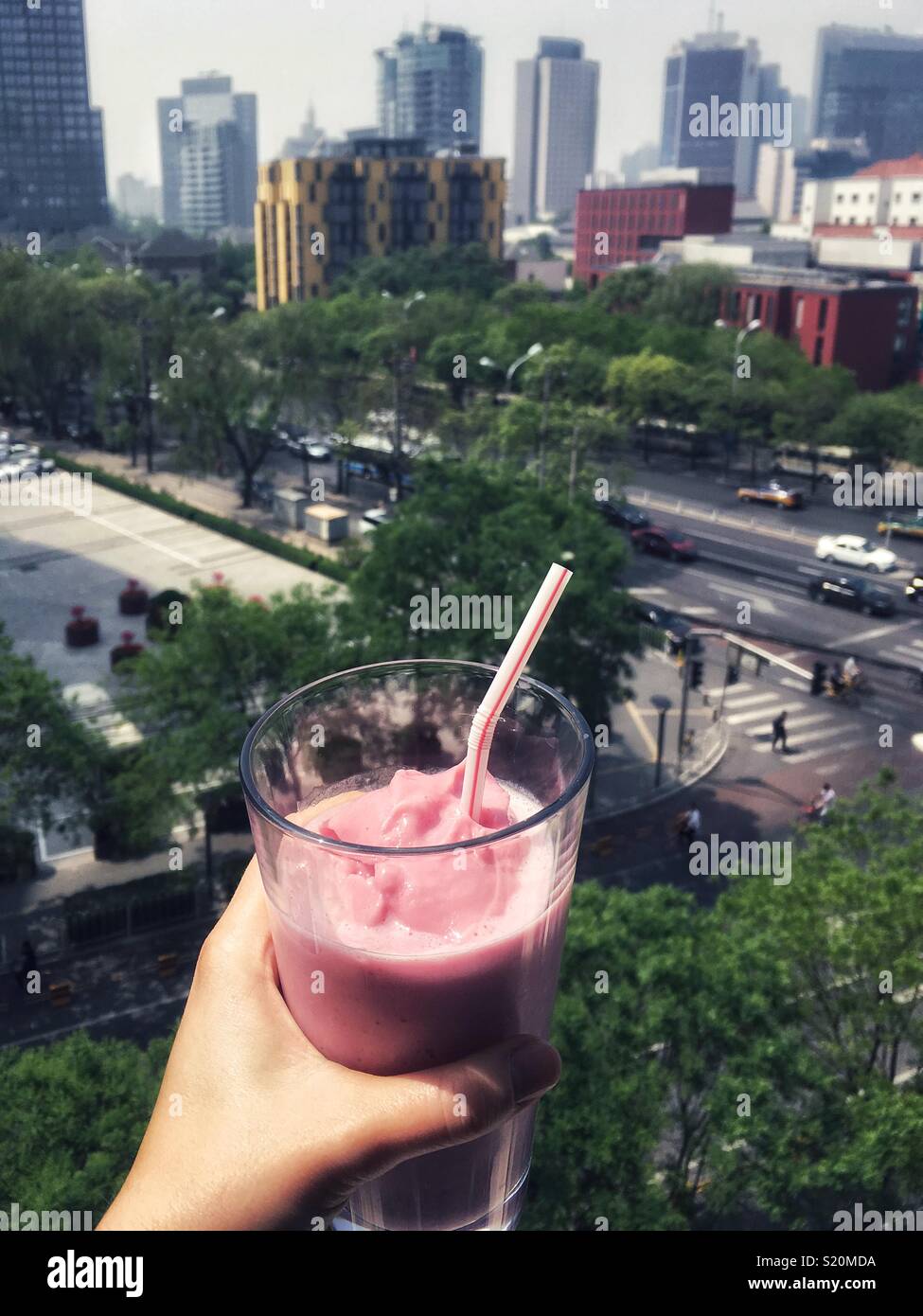 Have a glass of strawberry milkshake with overview skyline of Beijing, China. Stock Photo