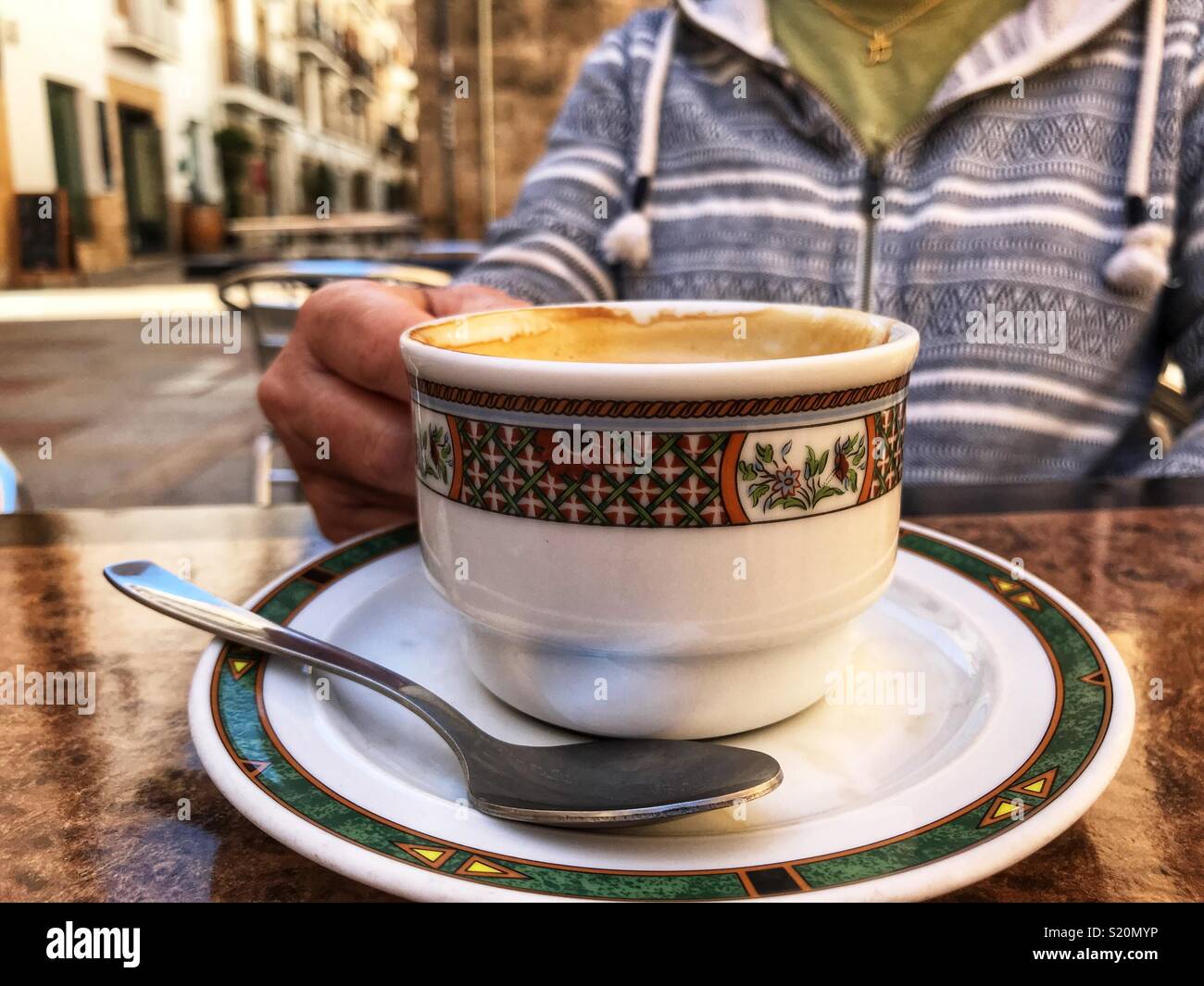 Woman enjoying a coffee at a pavement cafe in the Old Town of Javea/ Xabia, Costa Blanca, Spain - Smartphone Captured Stock Image