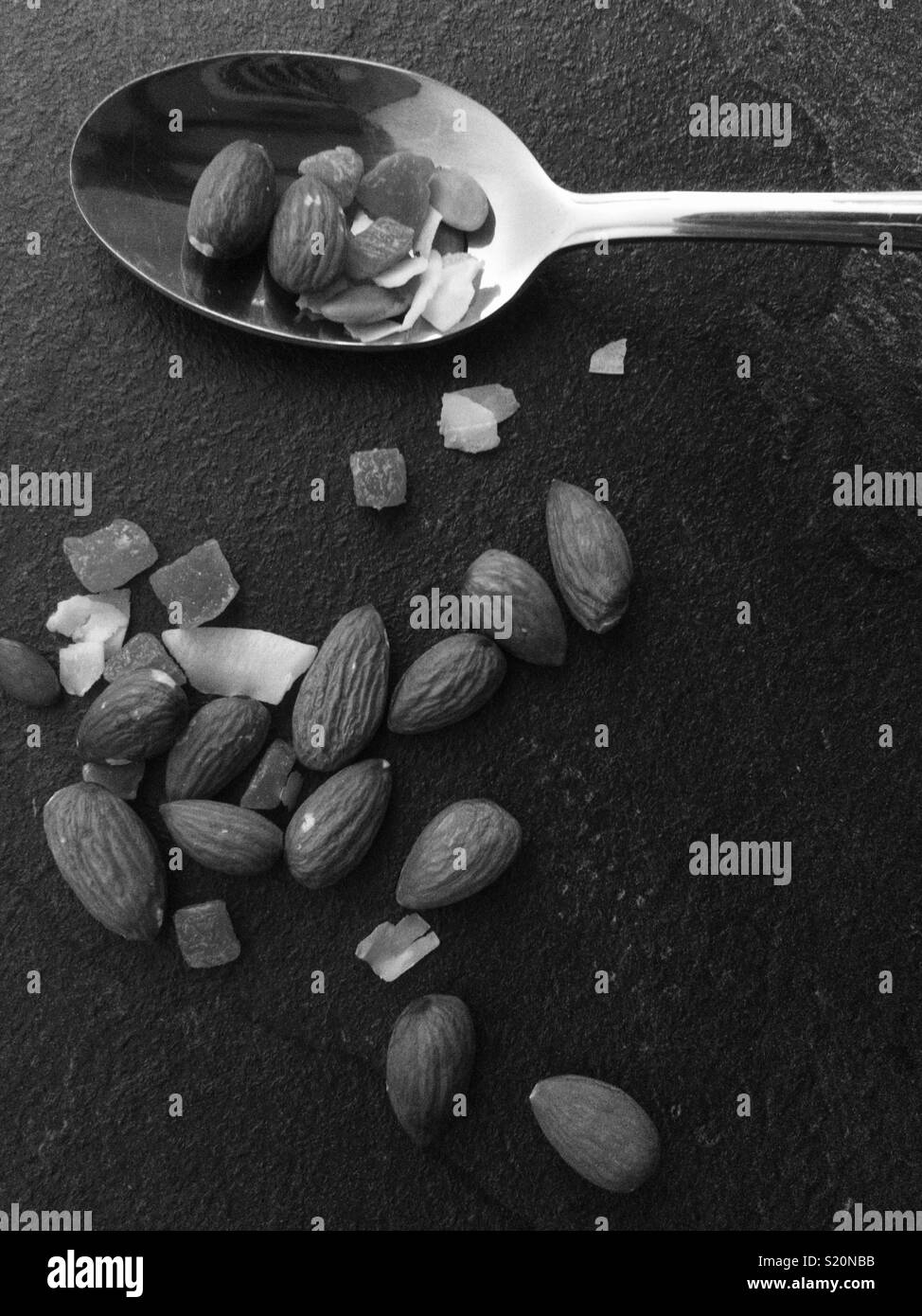 Black and white fruit, nuts and seeds on metal spoon Stock Photo