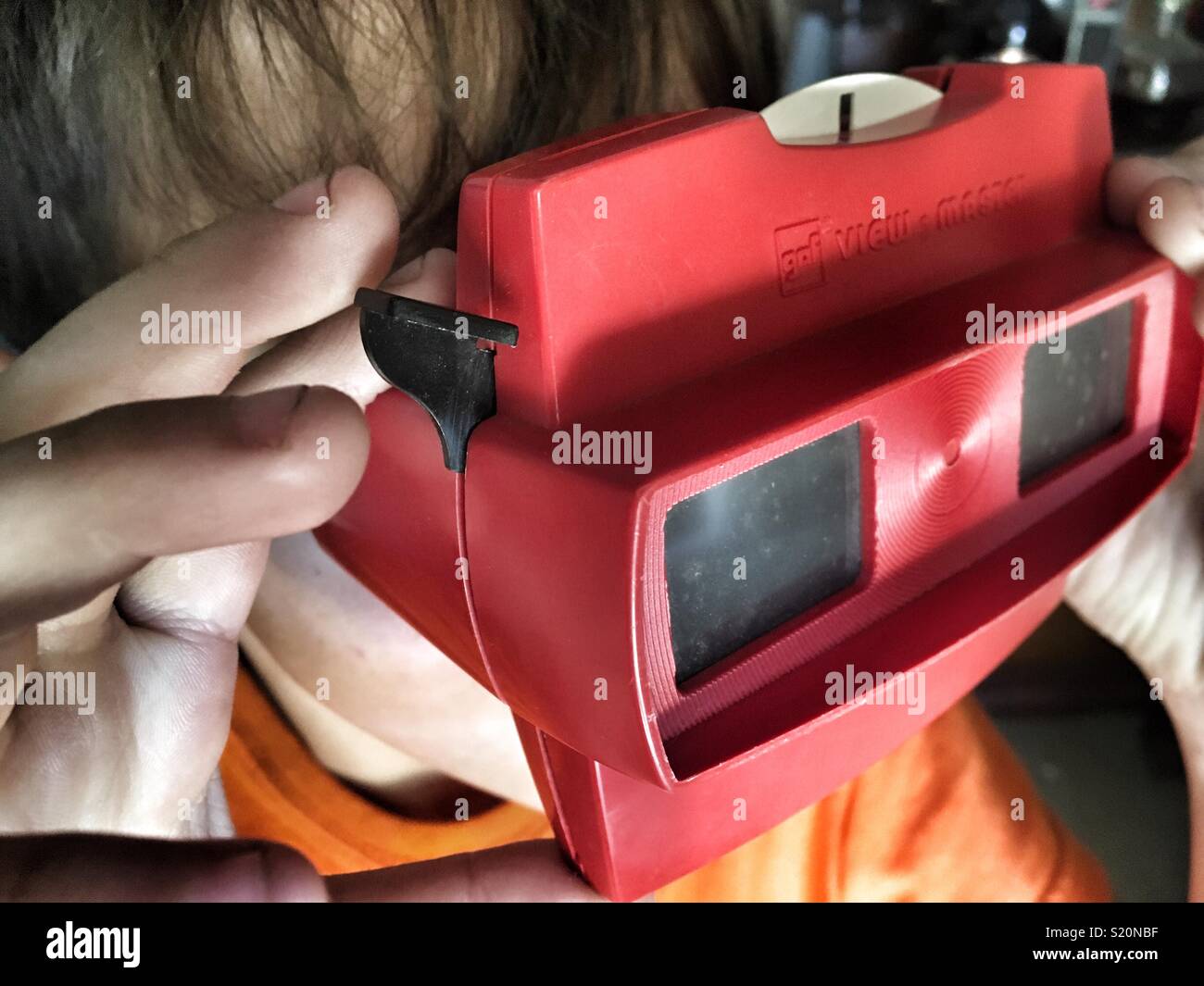 Toddler watching 3D images on View Master retro toy Stock Photo