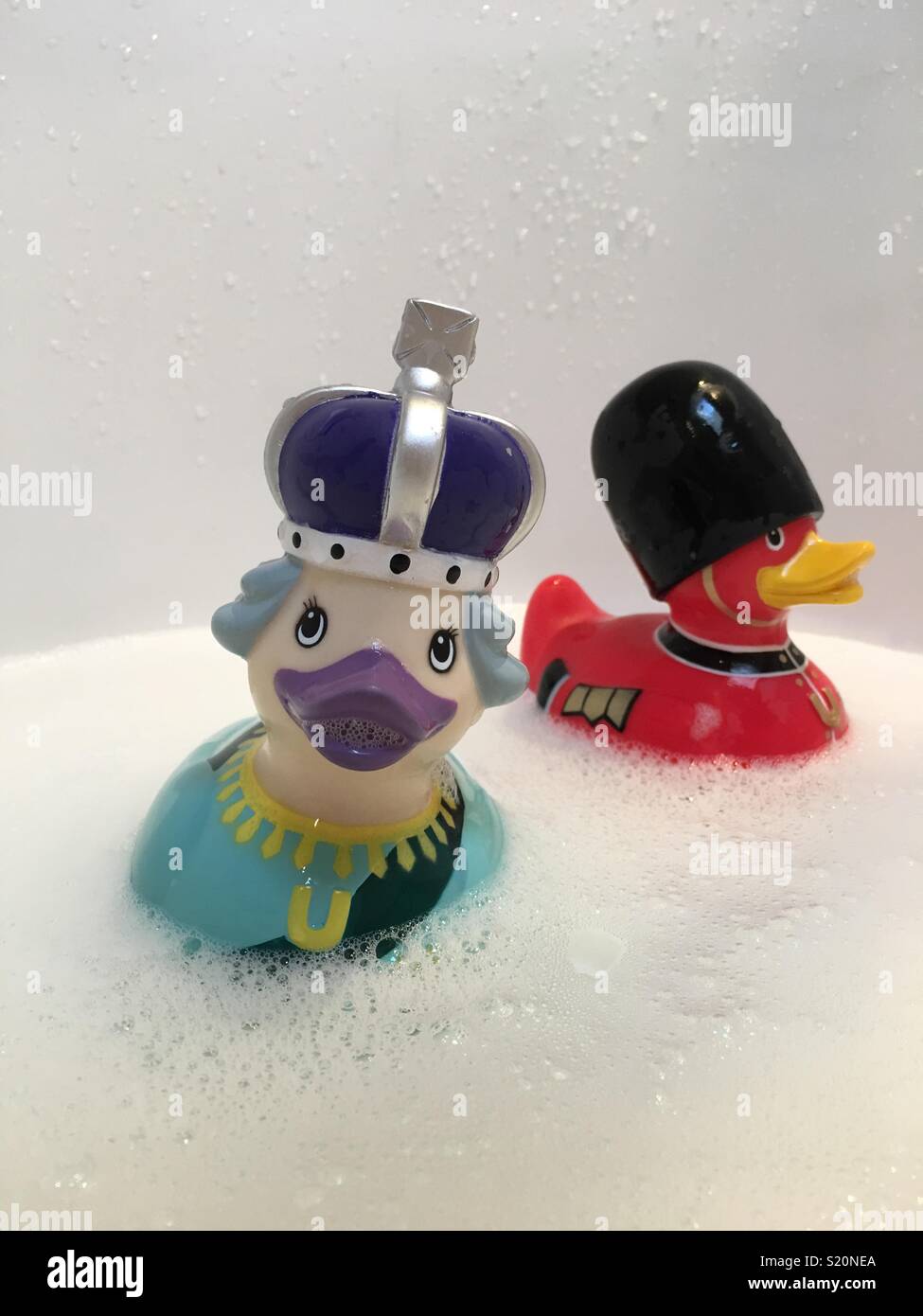 Queen Elizabeth and Queen’s Guard rubber duckies in a bathtub Stock Photo