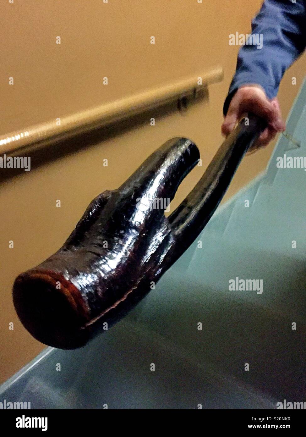 A Shillelagh is poised in a menacing way in a darkened staircase. Stock Photo