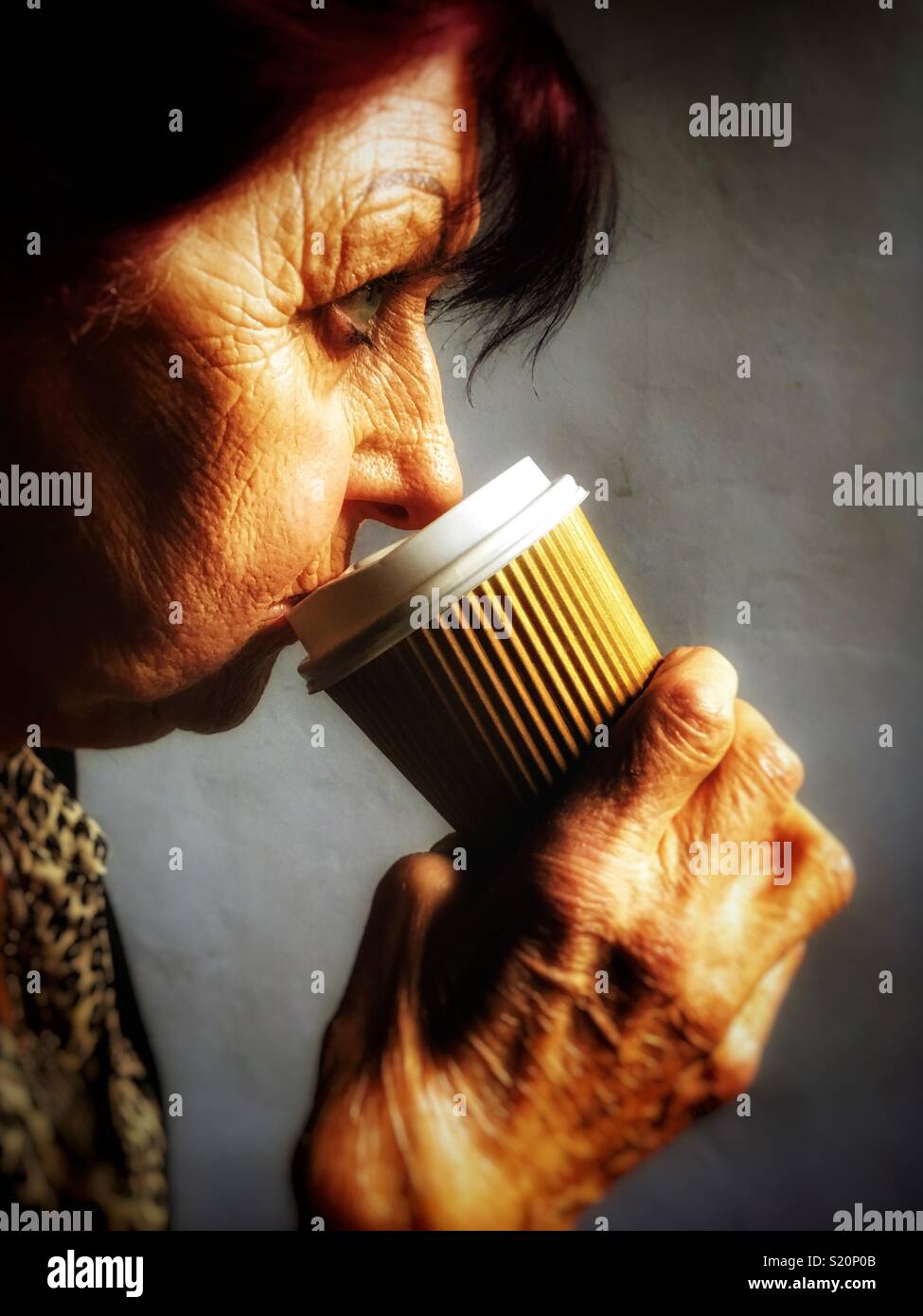 Woman drinking from a take away coffee cup - Smartphone Captured Stock Image
